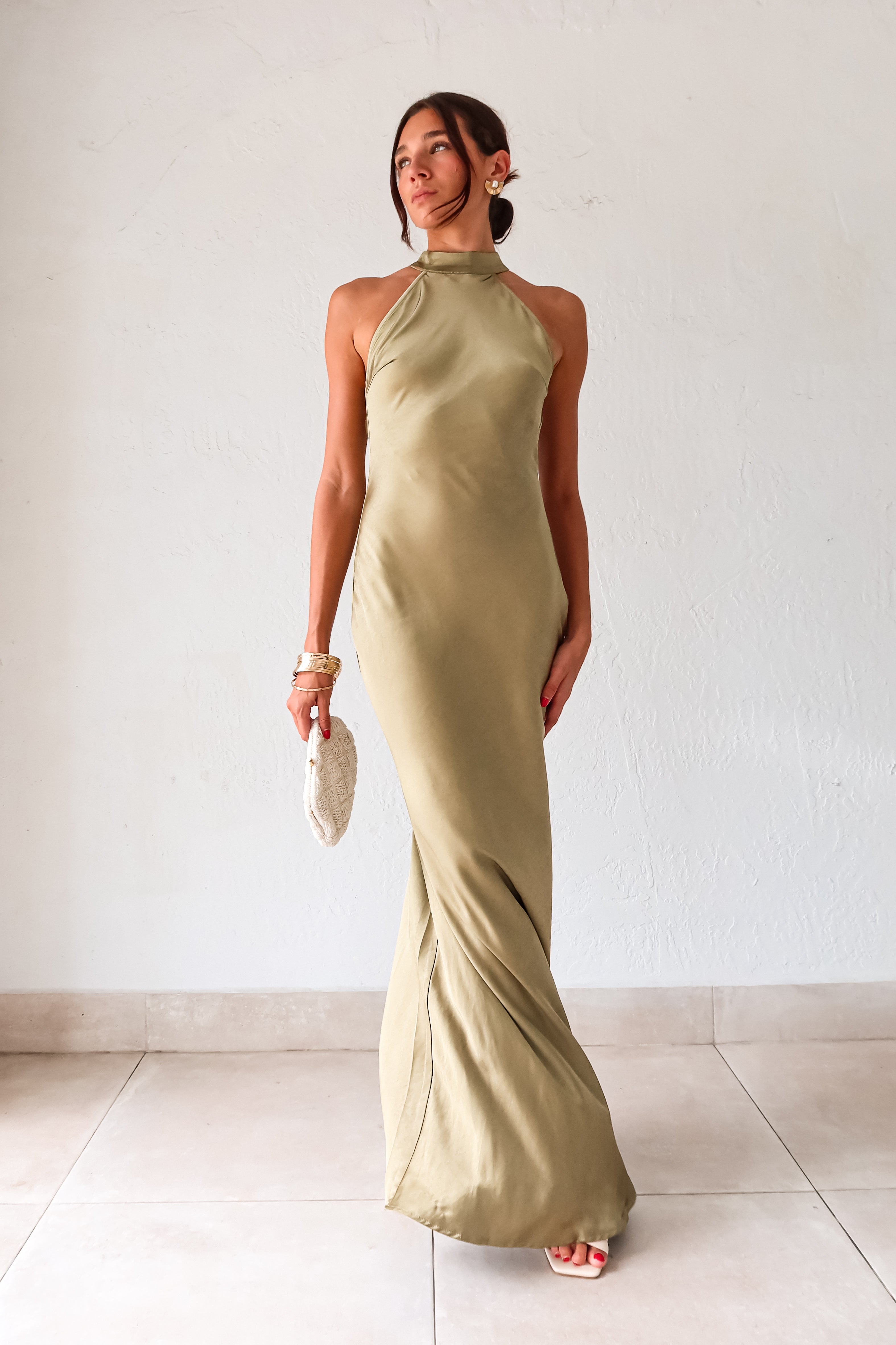 Take your style to the next level with the MAIN EVENT SATIN MAXI DRESS! This luxurious dress features a high neckline and adjustable tie in the back, perfect for creating a flattering silhouette. The draped back adds a touch of elegance to complete your look. Dress to impress with this stunning piece.