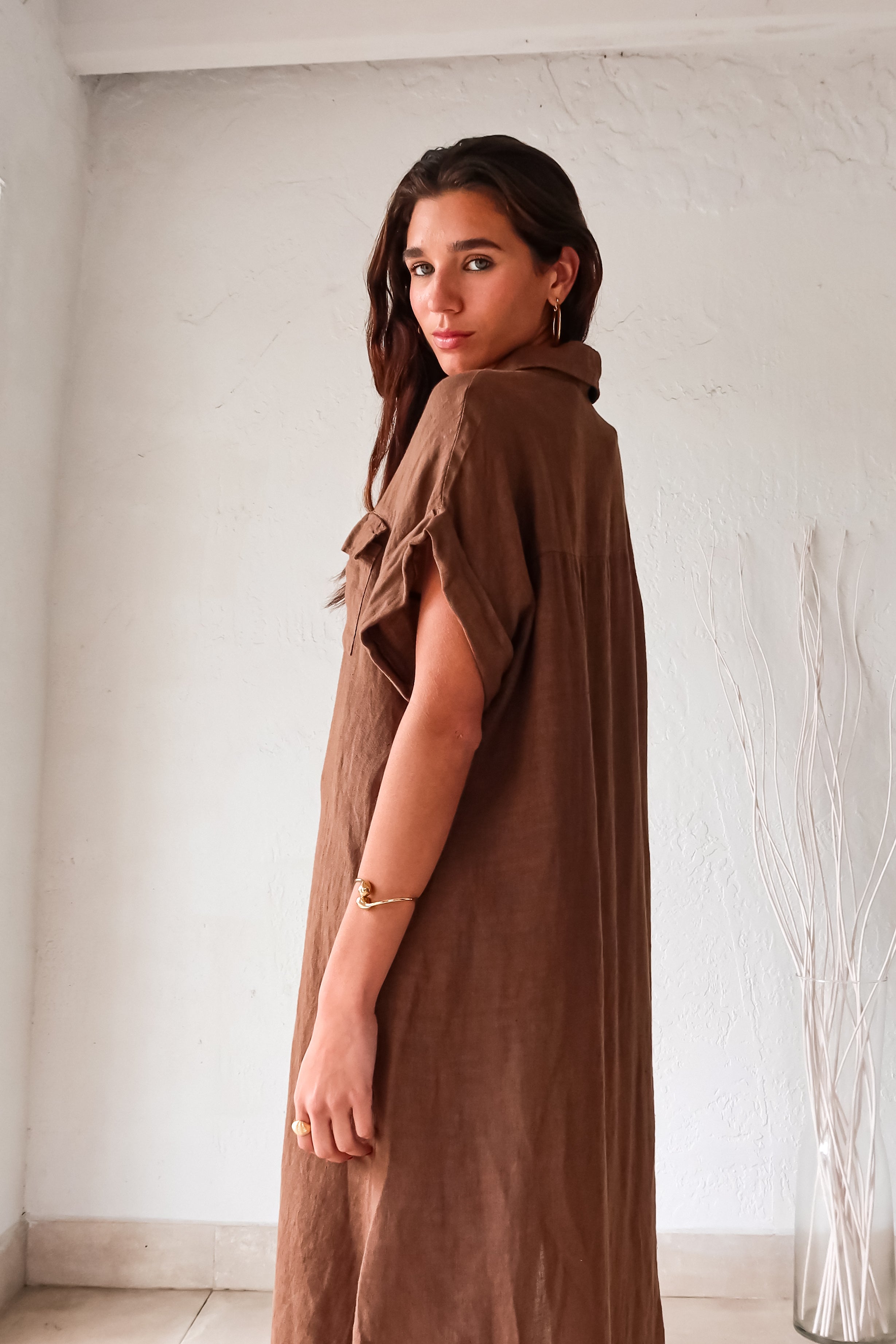 Turn heads in our LOS CAYOS LINEN MAXI DRESS BROWN. Made in Italy, this coffee brown dress features a button-down collar and front pockets. Its linen fabric offers a breezy, comfortable fit that can be worn as a cover-up. With leg slits and one size that fits XS-L, this dress is perfect for any occasion.