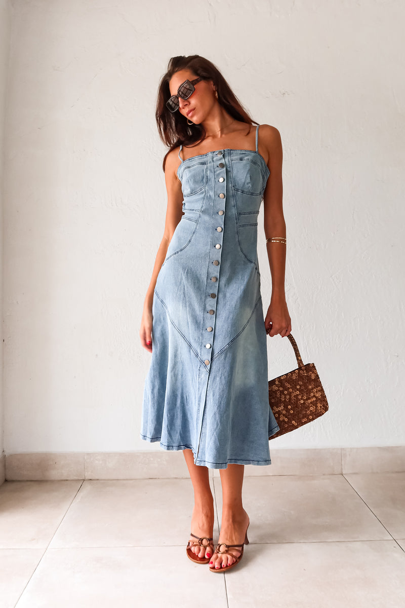 Get ready to rock a laid-back look with our Cypress Denim Midi Dress. This versatile piece features a front button down closure and adjustable shoulder straps for a customizable fit. The stretchy fabric and smocked backing provide ultimate comfort, while the chest stitch detail adds a touch of unique style. Non lined for a lightweight feel.