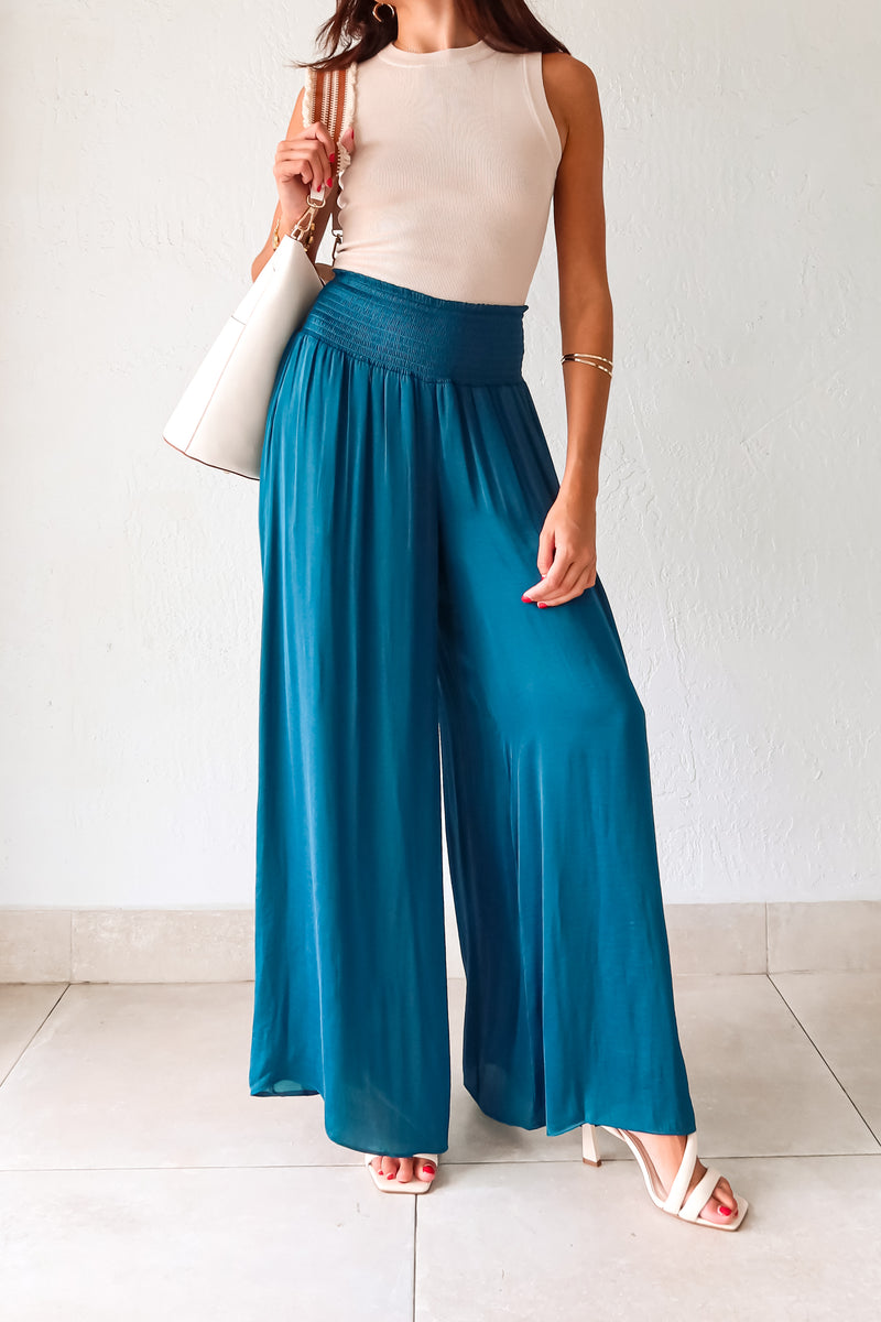 Get ready to make a statement in our MONDRIAN SATIN PANT. The lagoon blue satin fabric exudes luxury and the smocked waist ensures a comfortable fit. With a wide leg design, these pants will elevate any outfit, making you look and feel confident.