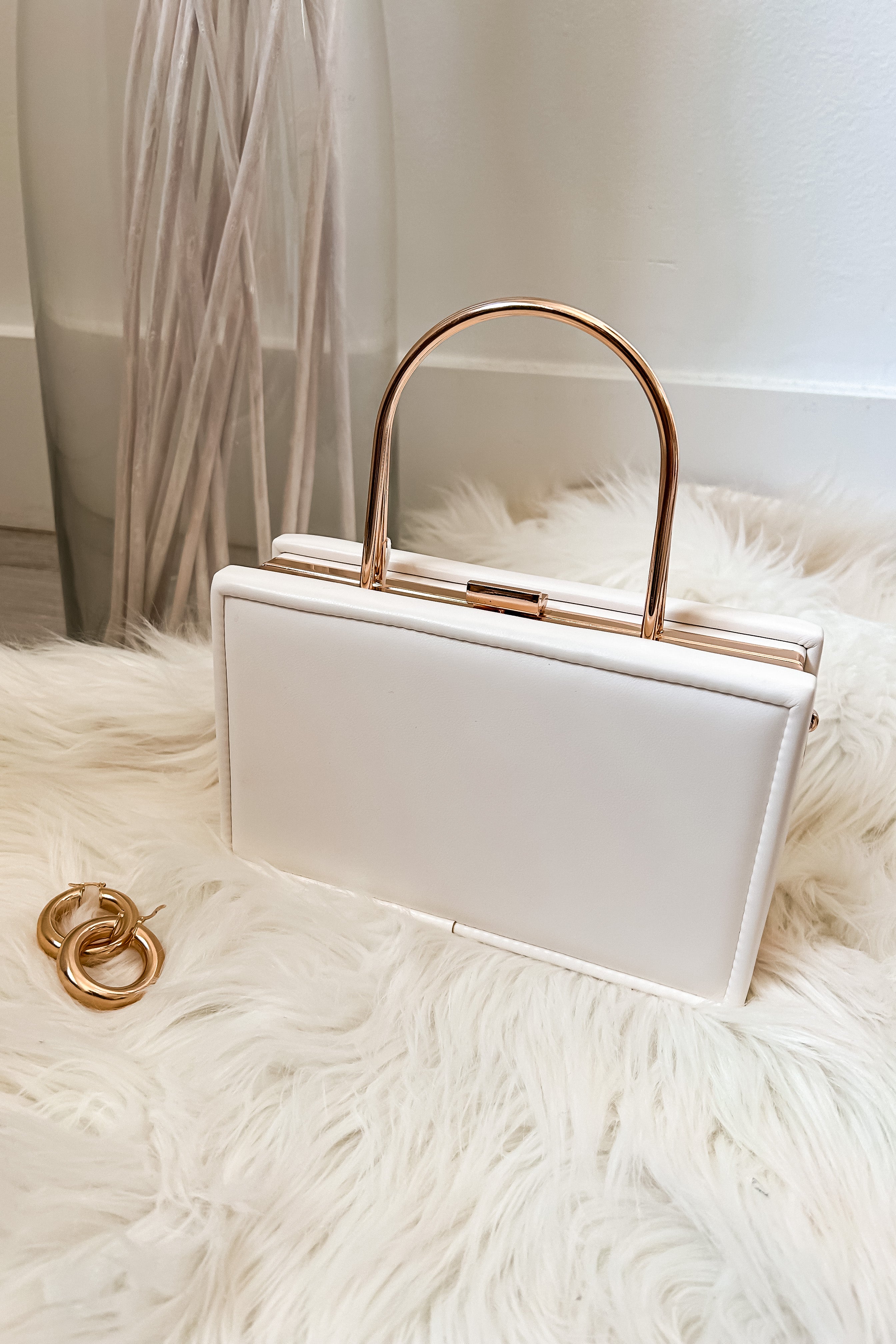 Add some trendiness to your outfit with the TRENDI BOX CLUTCH! This stylish ivory box purse features elegant gold hardware and a removable crossbody strap for versatility. Made with vegan leather, it's not only fashionable, but also guilt-free. A chic accessory for any occasion.