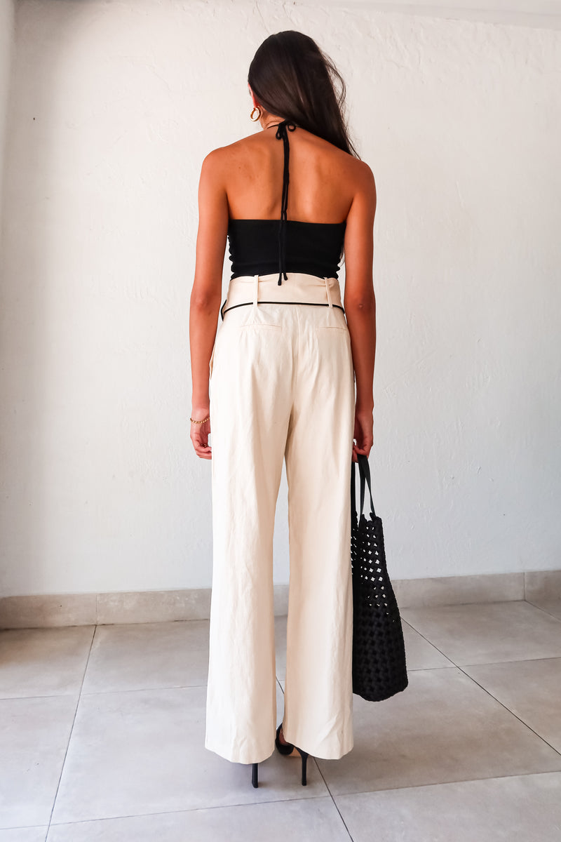 Effortlessly chic and comfortable, the ECLIPSE KNIT TOP in black is a must-have for your wardrobe. Made with ribbed stretchy fabric, it features a front knot design and a unique tie around the neck. Perfect for pairing with the Napoli Belted Linen Pant and the Silvana Woven Tote. Don't forget to size down for the perfect fit!