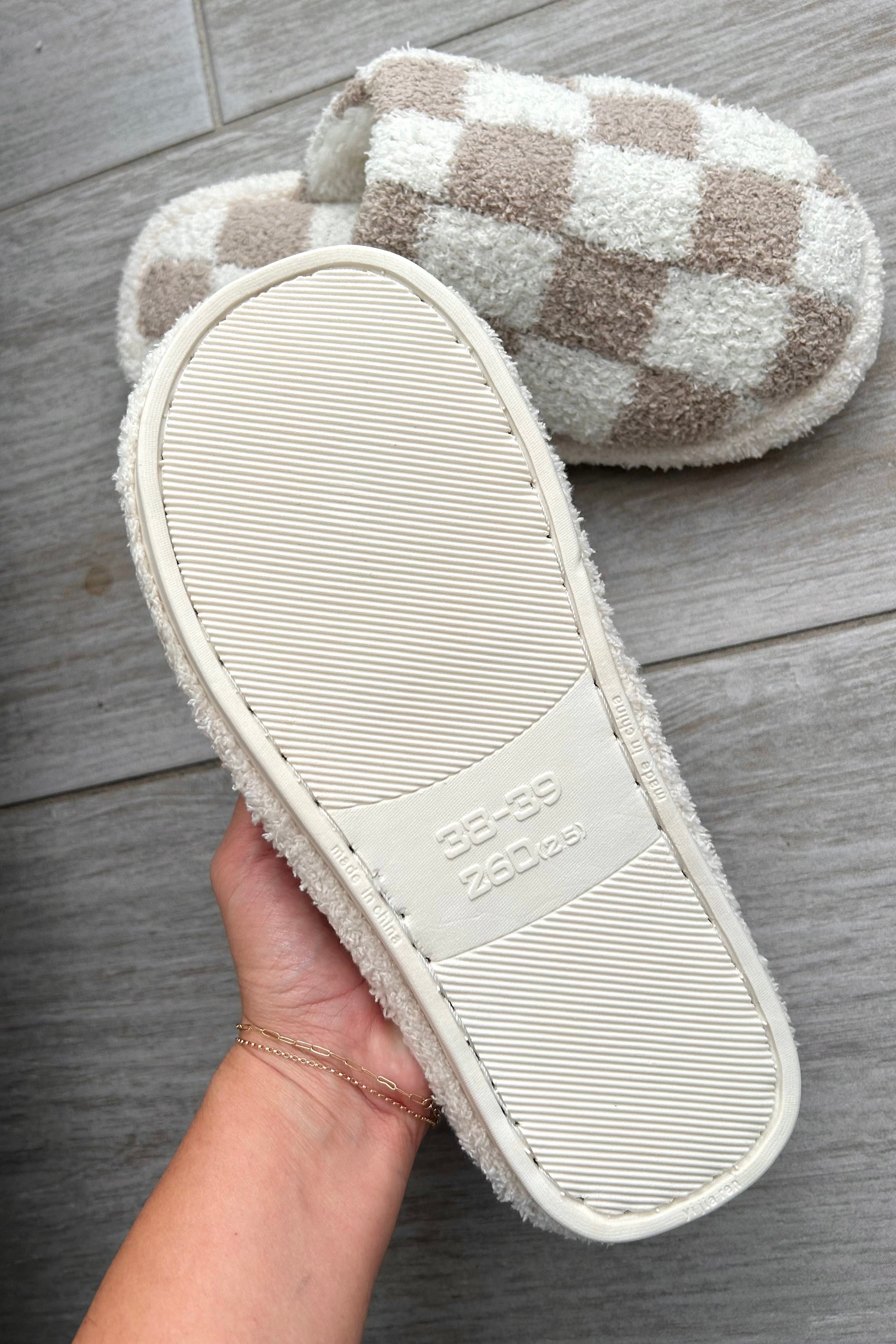 Step up your cozy game with our Checkmate Slippers! These white and khaki checker pattern slippers are not only stylish, but also made with comfy plush fabric for ultimate comfort. The cushioned sole will keep your feet happy all day long. It's game over for uncomfortable slippers!