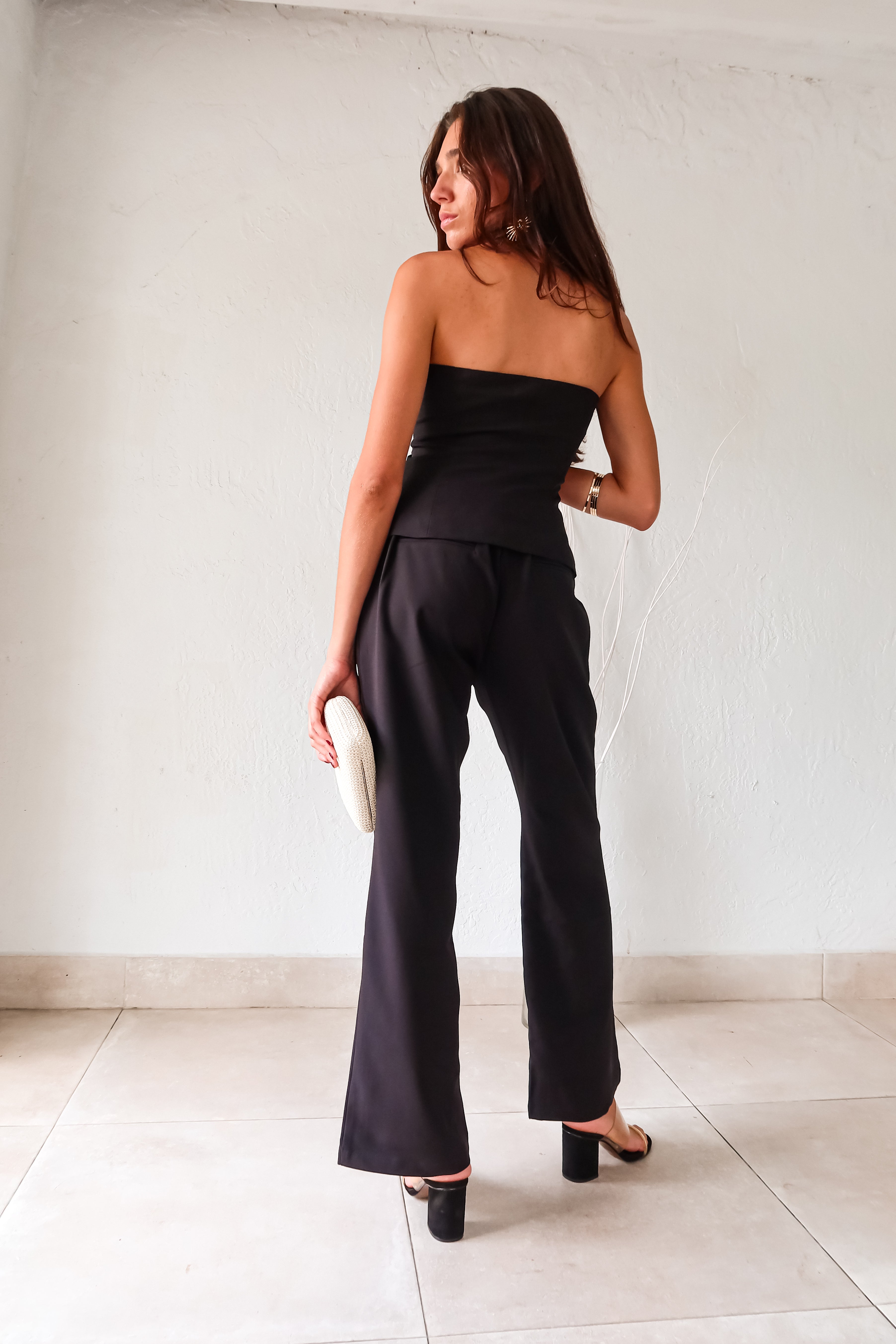 Experience ultimate comfort with style in our MOONLIT MOMENTS PANT SET. With a bustier vest top, front button and zipper clip closures, elastic waist backing, and front pockets, this black pant set is perfect for lounging or running errands. Top is lined for added support, bottoms are non-lined.