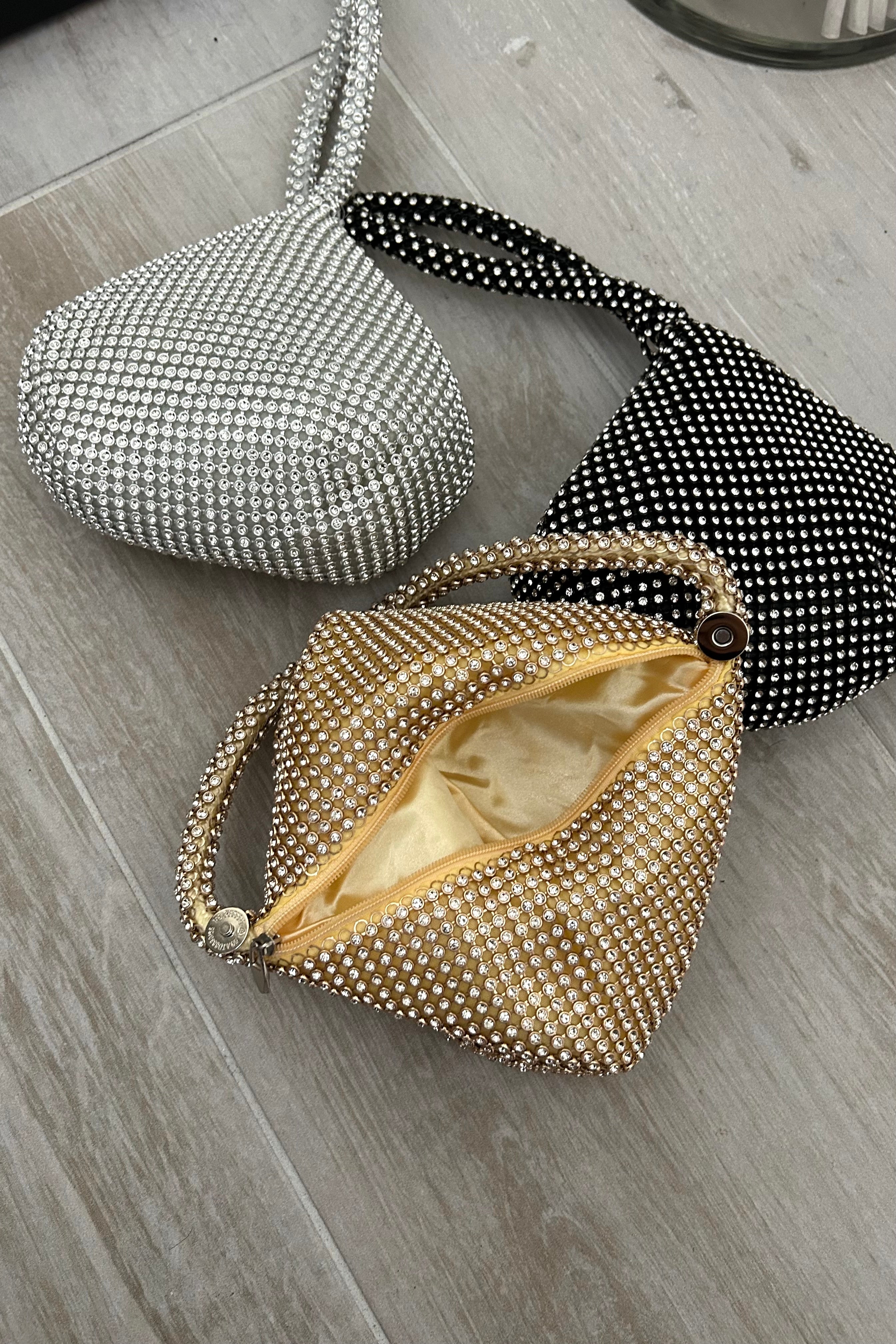 Add some sparkle to your style with the TWINKLE MINI HANDBAG! Featuring rhinestone detailing and available in black, silver, or gold, this mini handbag is the perfect accessory for adding a touch of glam to any outfit. With a zipper button closure, your essentials will stay safe while you shine!