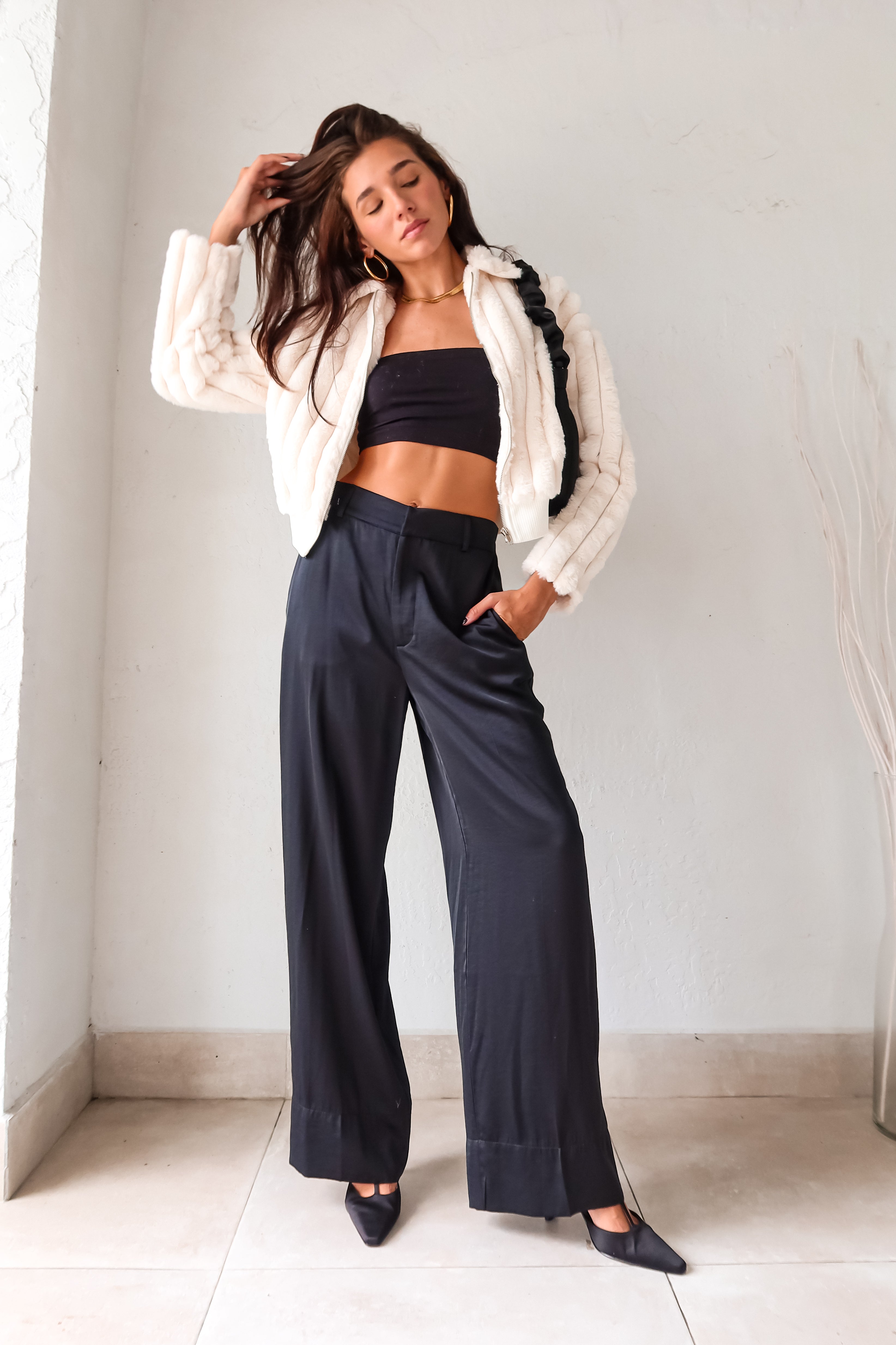 Slip into sleek style with the MONTMARTRE TROUSER in black. These satin trousers feature a zipper clip closure and elastic waist backing for a comfortable fit. With front pockets and belt loops, this pant is both functional and fashionable. Elevate your look with this versatile and chic piece!