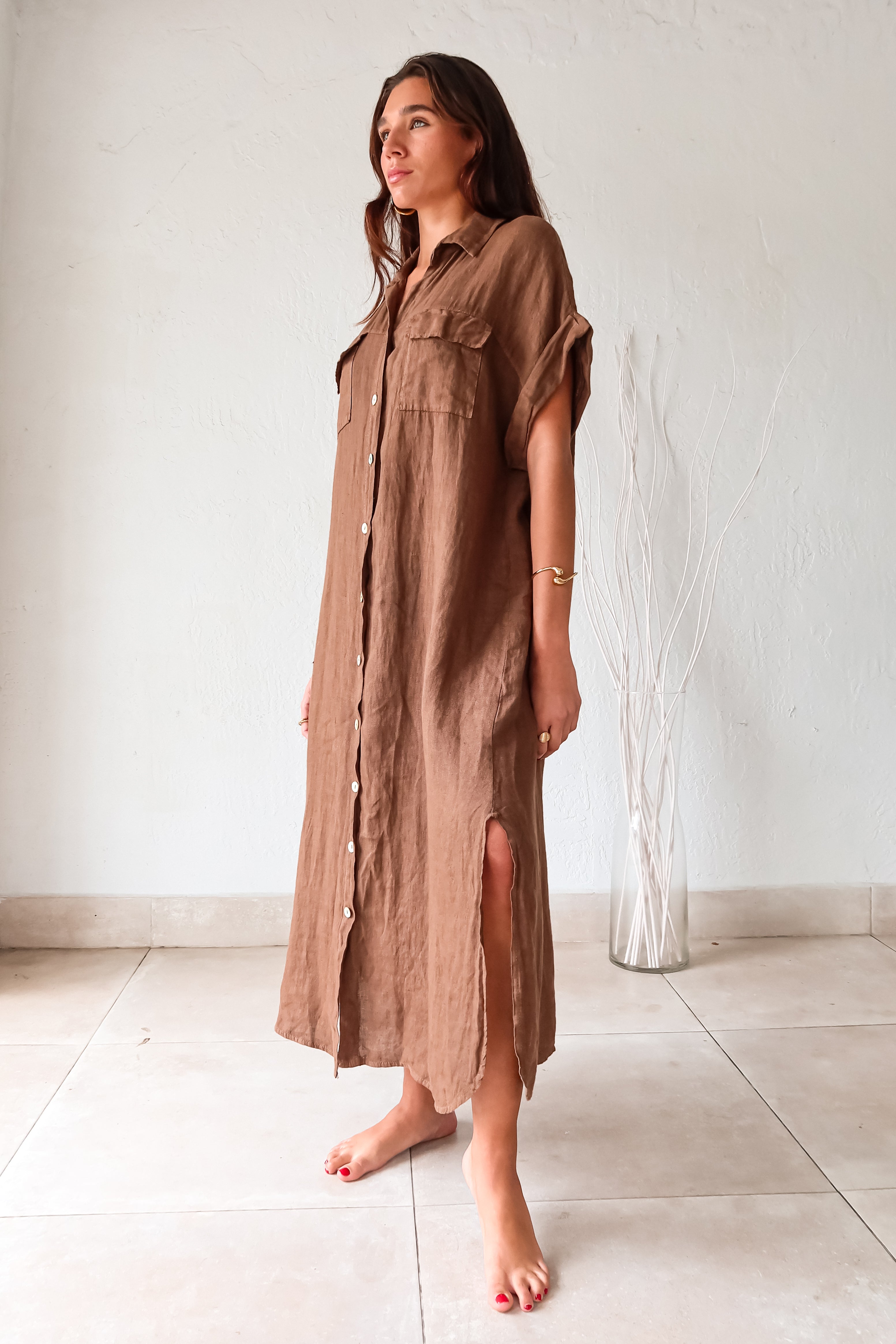 Turn heads in our LOS CAYOS LINEN MAXI DRESS BROWN. Made in Italy, this coffee brown dress features a button-down collar and front pockets. Its linen fabric offers a breezy, comfortable fit that can be worn as a cover-up. With leg slits and one size that fits XS-L, this dress is perfect for any occasion.