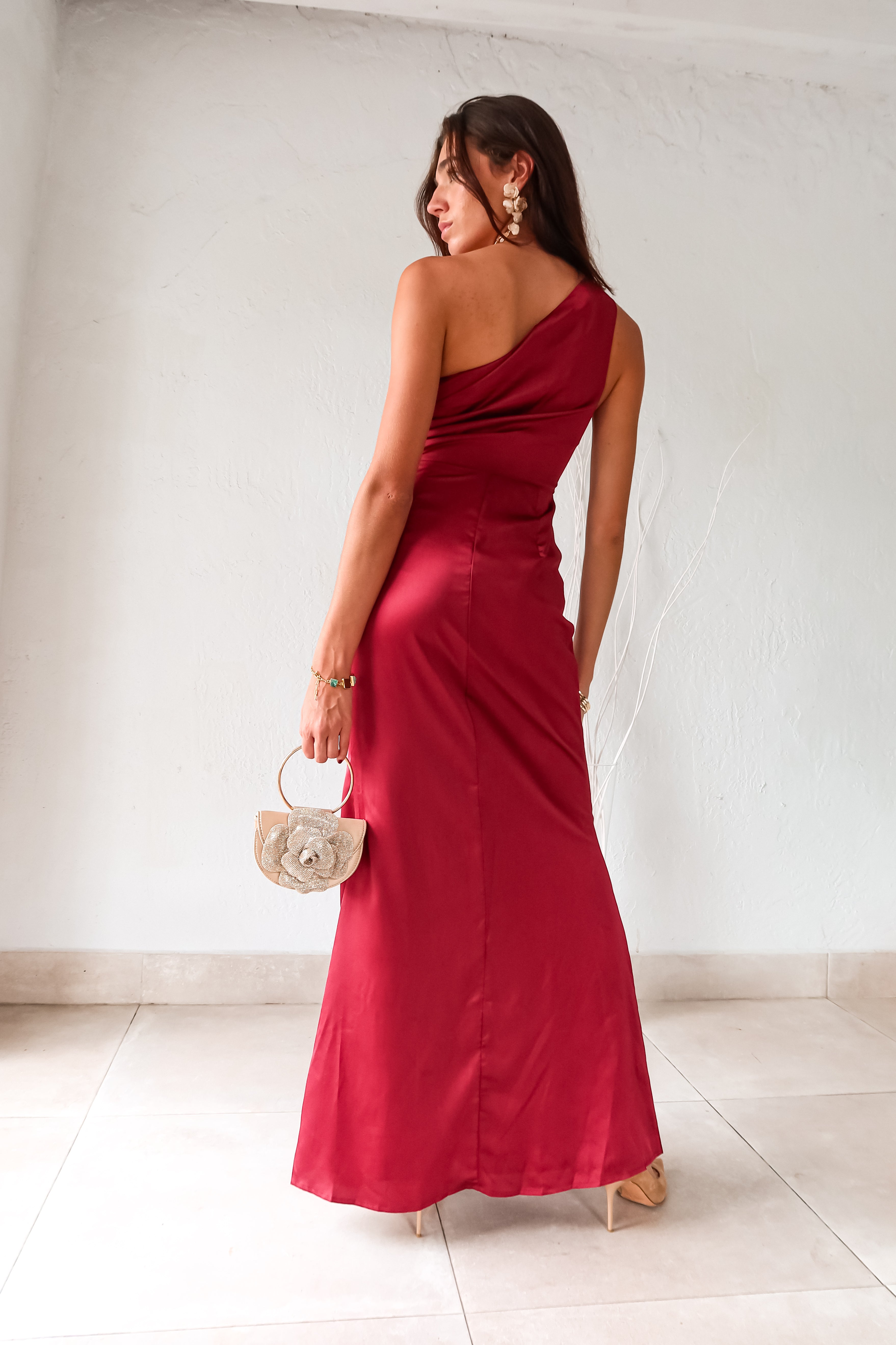 Indulge in the wine red NAPA VALLEY SATIN MAXI DRESS - a playful twist on a classic silhouette. The asymmetrical design features a right torso slit and left leg slit, while the side zipper closure adds a touch of convenience. Effortlessly chic and undeniably unique, this dress is perfect for any occasion.