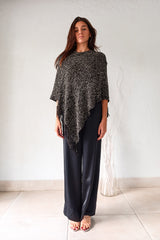 Embrace your wild side with our FULL MOON LUREX PONCHO. The black lurex sweater poncho features silver fabric detailing, a fringed bottom, and stretchy fabric for a comfortable fit that flatters any size. Perfect for a night out or cozying up by the fire. One size fits XS-L.