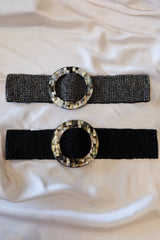 OZ Beaded Belt! Handcrafted in Bali, this stretchy and versatile belt features a unique abalone circle buckle and beautiful black or silver beading. One size fits all, making it the perfect accessory for any outfit.