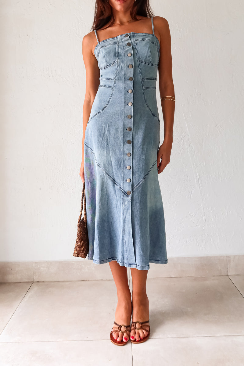 Get ready to rock a laid-back look with our Cypress Denim Midi Dress. This versatile piece features a front button down closure and adjustable shoulder straps for a customizable fit. The stretchy fabric and smocked backing provide ultimate comfort, while the chest stitch detail adds a touch of unique style. Non lined for a lightweight feel.