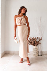 BRODEUX SATIN SKIRT SET! This luxe nude satin set features a one shoulder bubble crop top with a front twist detail, and a midi skirt with a side zipper closure and elastic band for a comfortable fit. Lined top and non-stretch material.