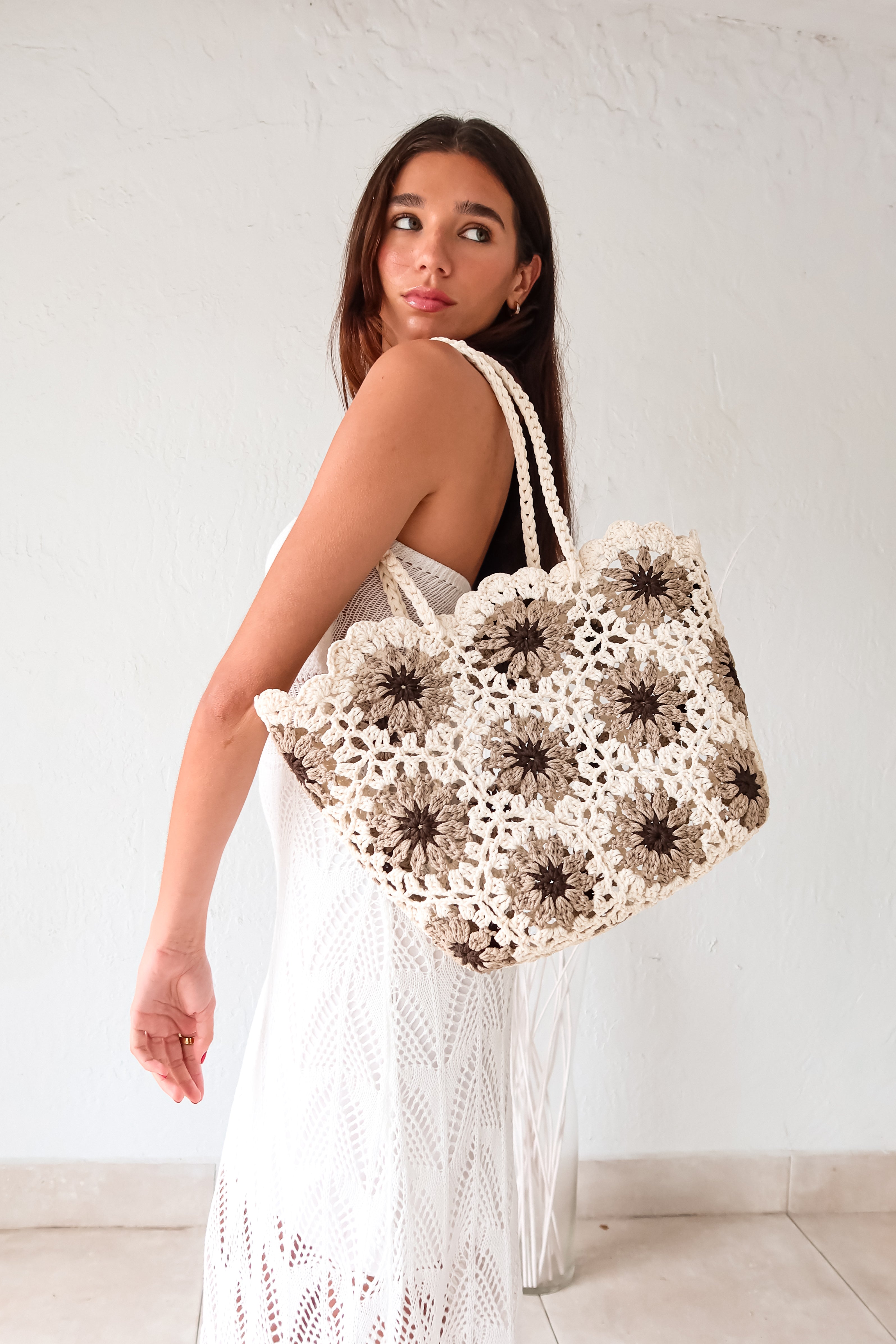 Get ready to lounge in style with our Lazy Daisy Woven Tote! This cream tote features a playful brown flower design, perfect for any laid-back fashionista. With a spacious 12in height, 12in length, and 4in width, you'll have plenty of room for all your essentials. Time to ditch the boring bags and add some fun to your collection!