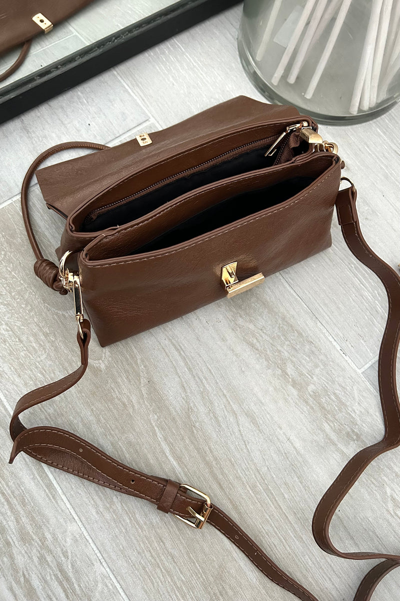 Introducing the LEXI PURSE - the perfect accessory for any outfit! Made with brown vegan leather, this purse is both stylish and sustainable. Carry it with ease thanks to the removable hand strap and secure your belongings with the gold buckle closure.&nbsp;