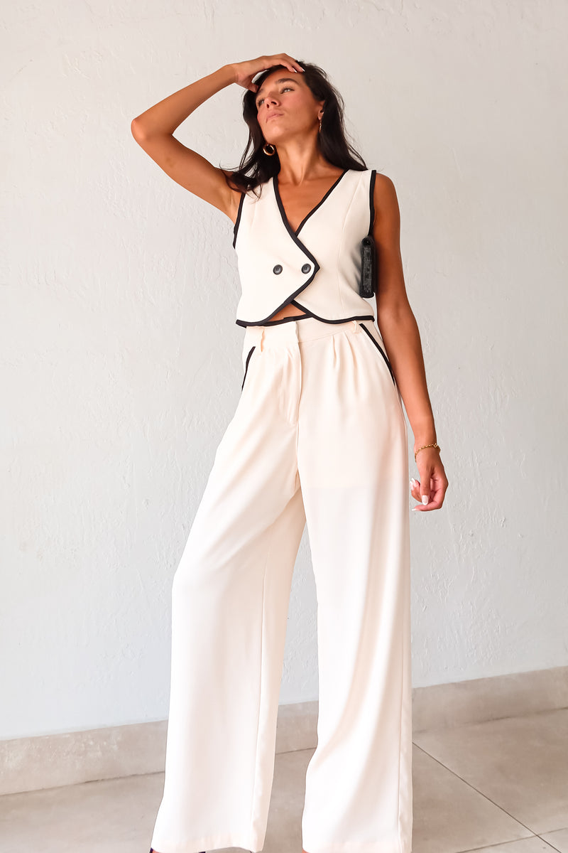 Unleash your inner fashionista with our BAL HARBOUR VEST PANT SET. This cream vest pant set features a unique black lining and an adjustable fit with a back buckle detail. The front button closure top and zipper clip closure pants provide practicality, while the front pockets add a touch of functionality. Sophisticated yet playful, this set will elevate your wardrobe. 