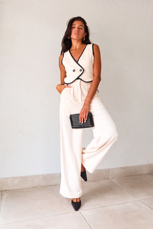 Unleash your inner fashionista with our BAL HARBOUR VEST PANT SET. This cream vest pant set features a unique black lining and an adjustable fit with a back buckle detail. The front button closure top and zipper clip closure pants provide practicality, while the front pockets add a touch of functionality. Sophisticated yet playful, this set will elevate your wardrobe. 