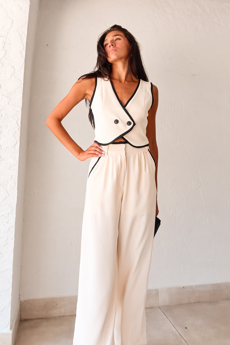 Unleash your inner fashionista with our BAL HARBOUR VEST PANT SET. This cream vest pant set features a unique black lining and an adjustable fit with a back buckle detail. The front button closure top and zipper clip closure pants provide practicality, while the front pockets add a touch of functionality. Sophisticated yet playful, this set will elevate your wardrobe. 