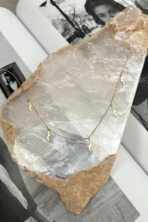 Get struck by style with the BOLT CHOKER! This gold plated choker features a charming lightning bolt detail and is made with tarnish-resistant, hypoallergenic sterling silver. No need to fear an allergic reaction or dull, tarnished jewelry. This choker is sure to add a shock of chic to any outfit.