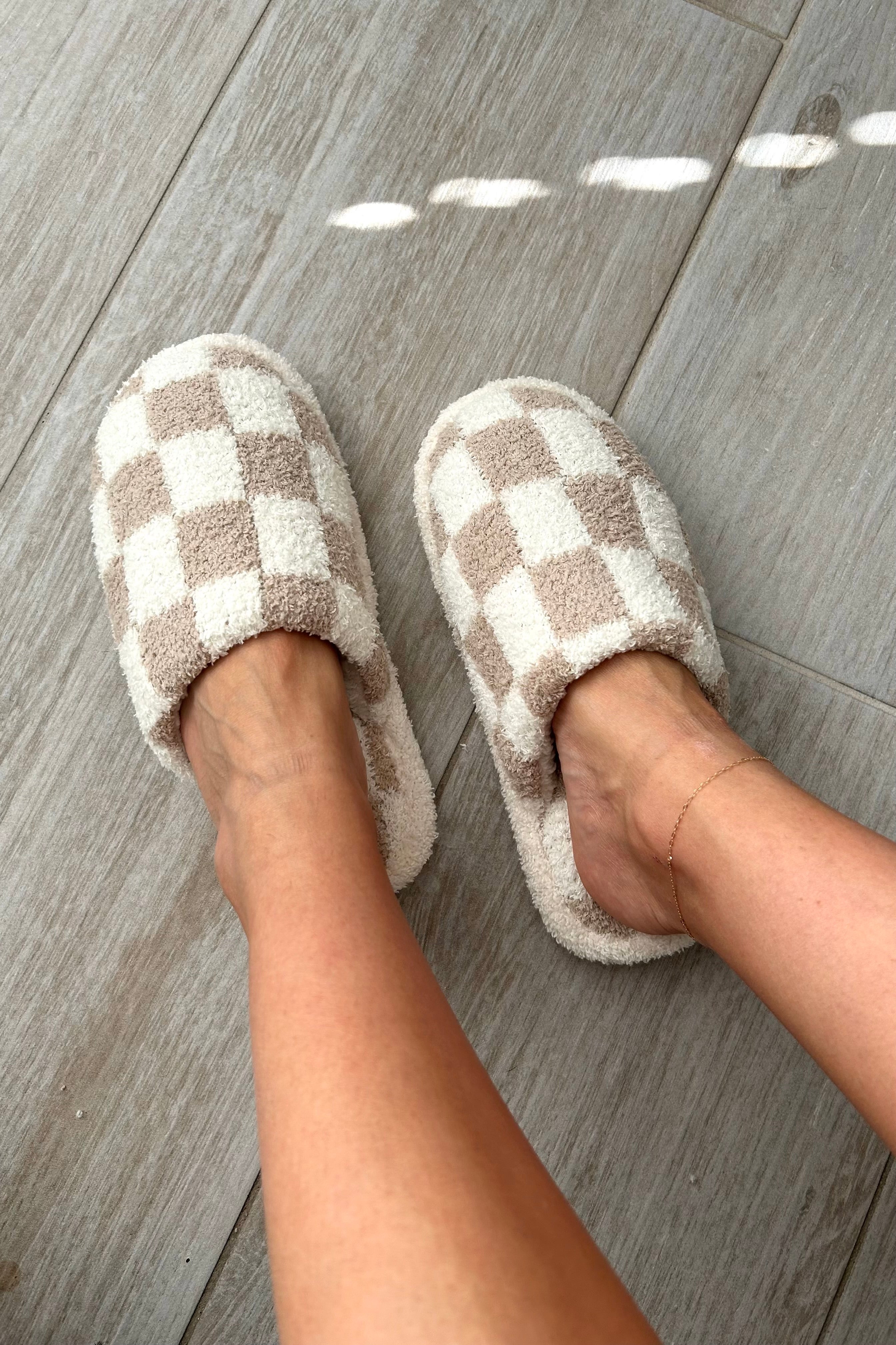 Step up your cozy game with our Checkmate Slippers! These white and khaki checker pattern slippers are not only stylish, but also made with comfy plush fabric for ultimate comfort. The cushioned sole will keep your feet happy all day long. It's game over for uncomfortable slippers!