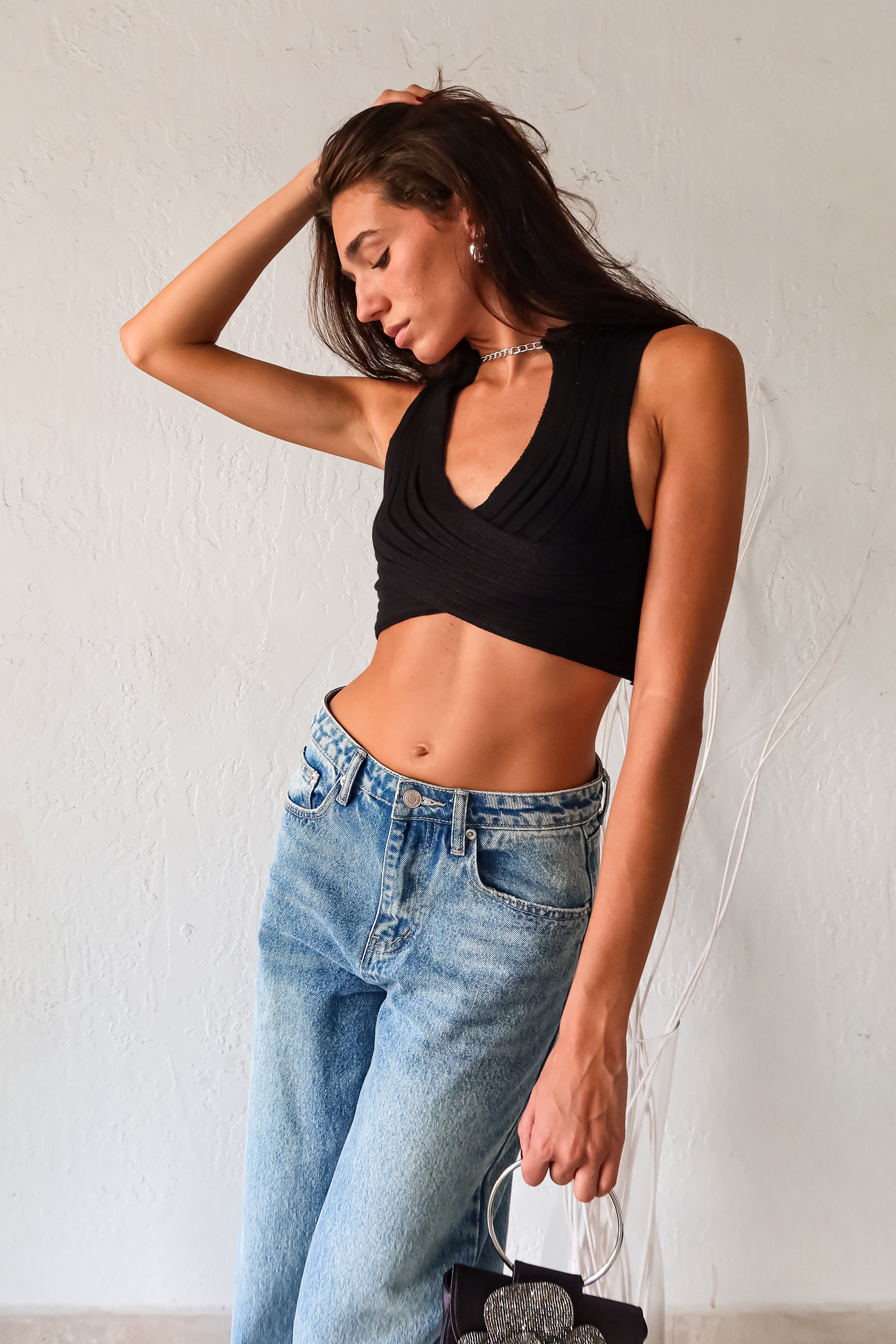 Add some edge to your wardrobe with our black ribbed crop top! Featuring a unique neck chain detail and front overlap design, this top is sure to turn heads. The stretchy fabric ensures a comfortable fit for all-day wear.