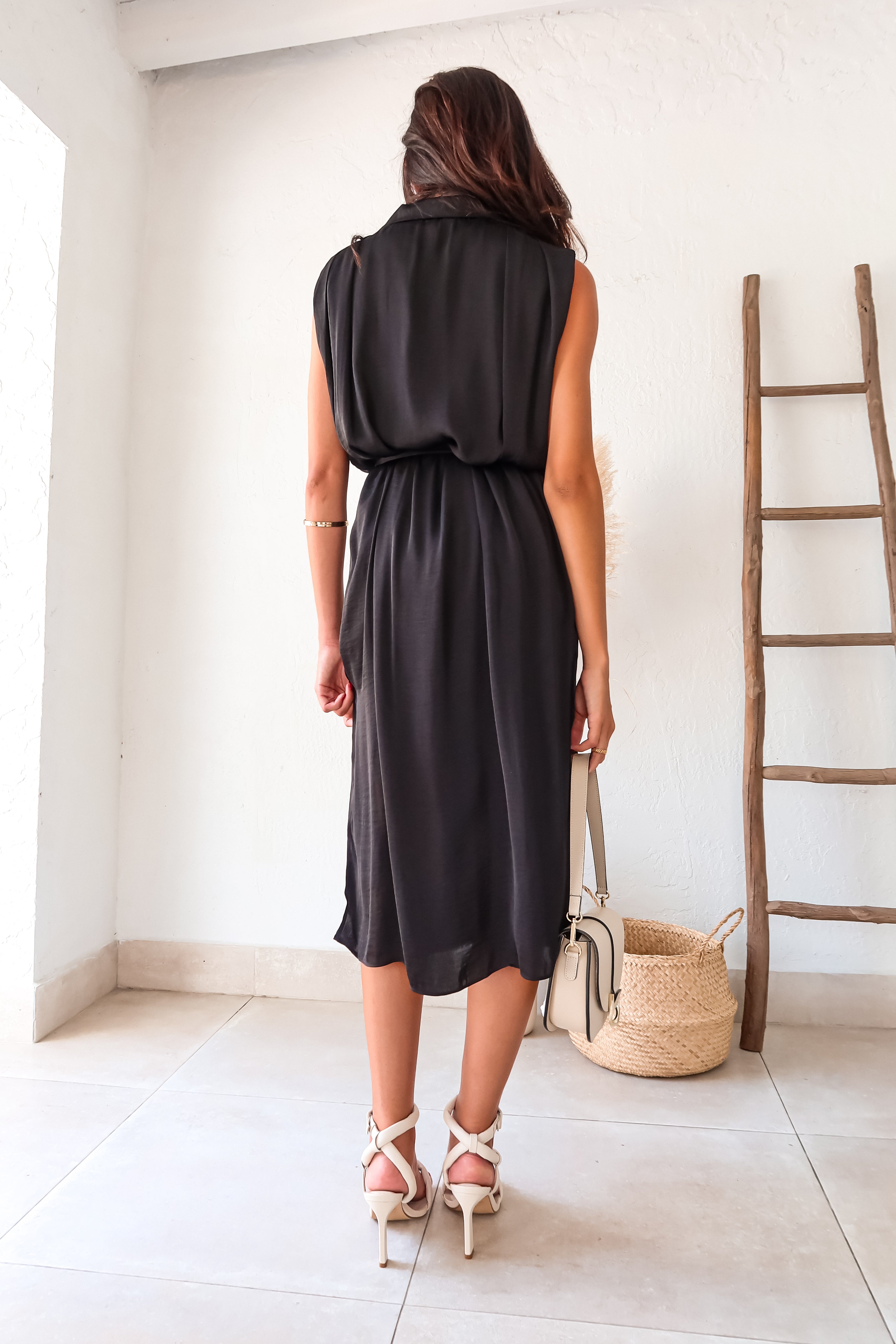 Elevate your style with the MILLER SATIN SHIRT DRESS. This black satin dress features a collared neckline and front button closure for a versatile look. The sash detail adds a touch of elegance, while the double leg slits and lined design provide comfort and movement. Perfect for any occasion.