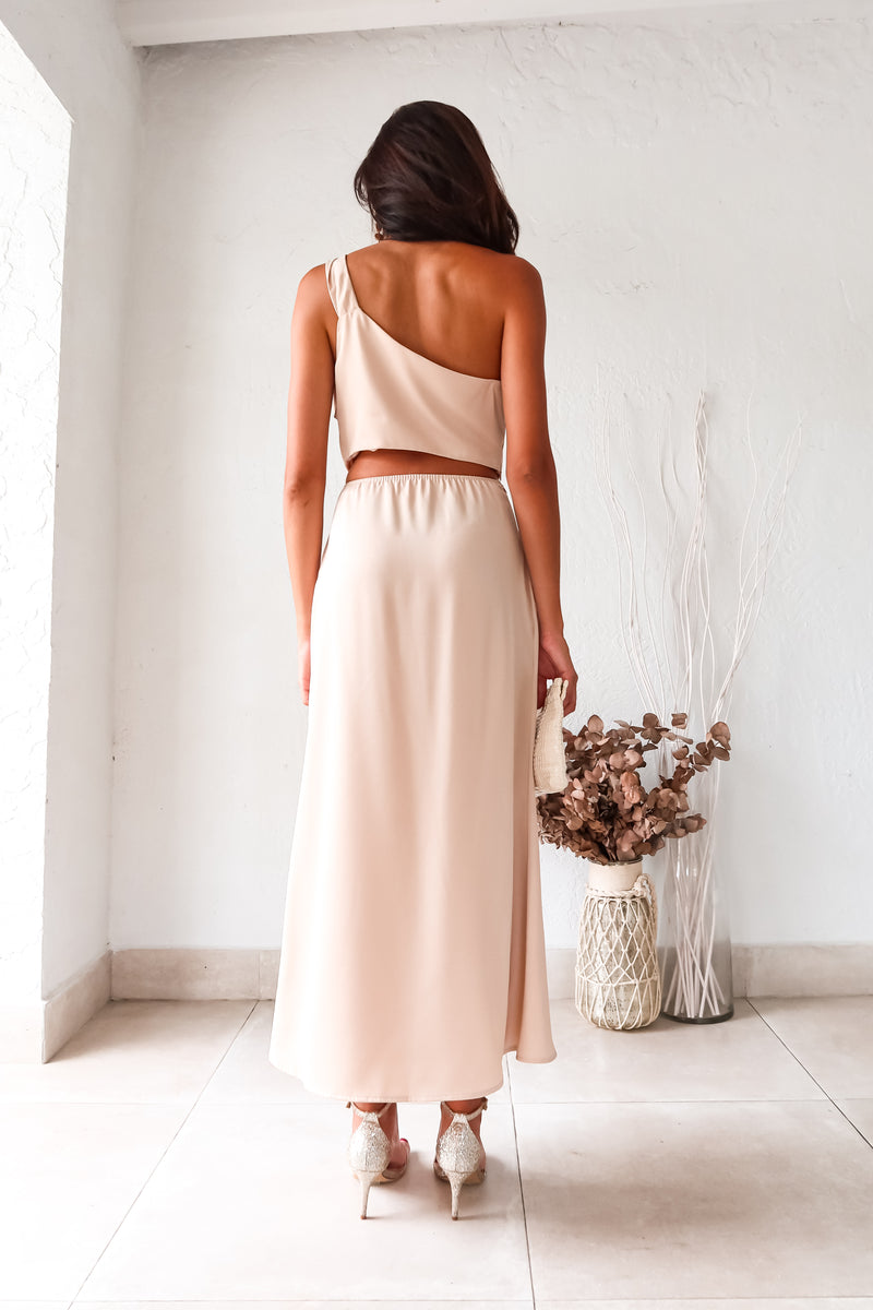 BRODEUX SATIN SKIRT SET! This luxe nude satin set features a one shoulder bubble crop top with a front twist detail, and a midi skirt with a side zipper closure and elastic band for a comfortable fit. Lined top and non-stretch material.