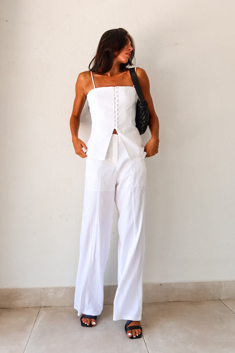 Transform your wardrobe with our DAY TO NIGHT LINEN PANT SET! This white set features a pleated tank top with adjustable shoulder straps and a front button closure, paired with non-stretch pants that have a zipper button closure and convenient front pockets. Perfect for any occasion, top lined and bottom non-lined for added comfort and style.