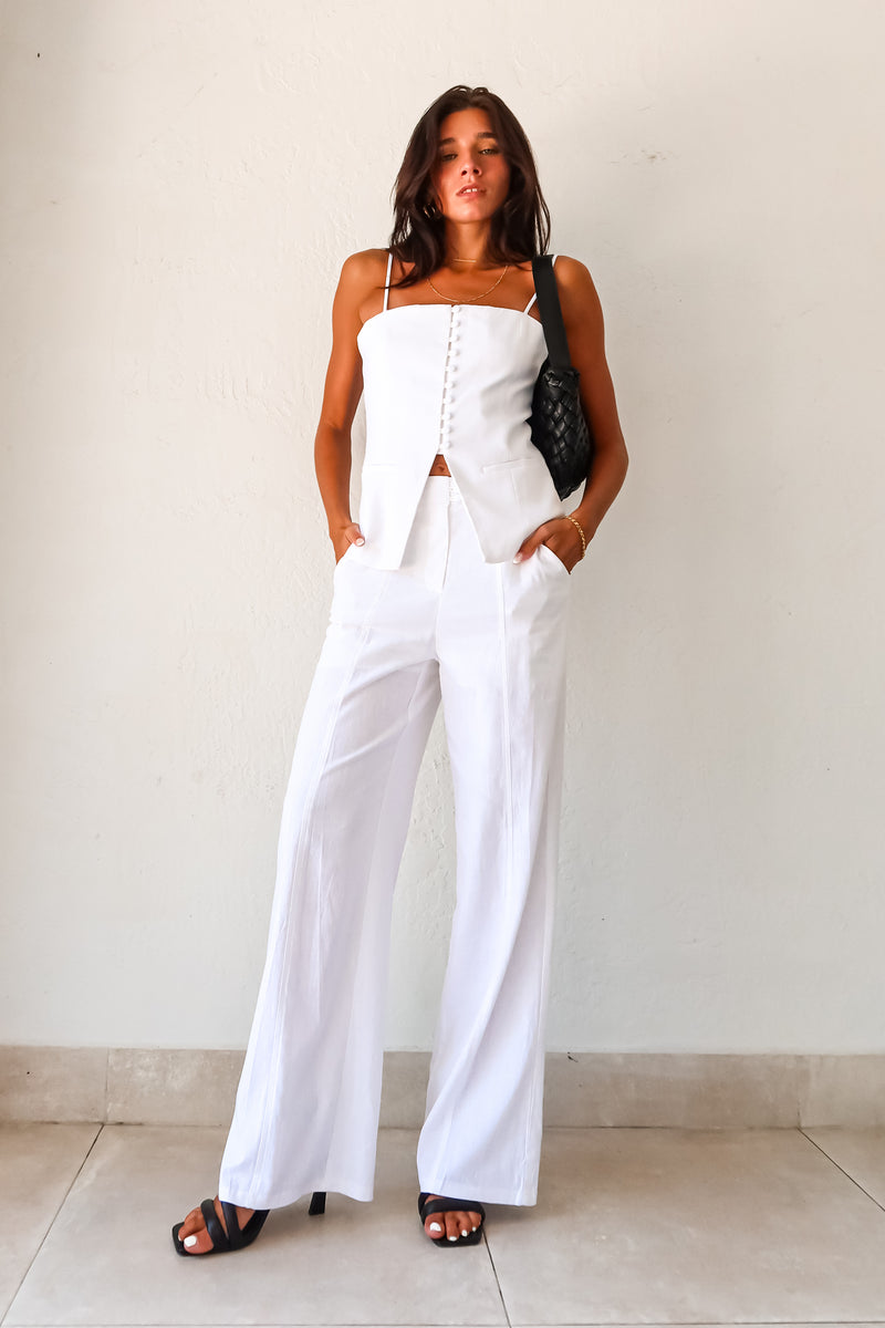 Transform your wardrobe with our DAY TO NIGHT LINEN PANT SET! This white set features a pleated tank top with adjustable shoulder straps and a front button closure, paired with non-stretch pants that have a zipper button closure and convenient front pockets. Perfect for any occasion, top lined and bottom non-lined for added comfort and style.