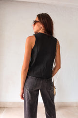 Stay cool and stylish with the London Vest Top in Black. Featuring a unique crochet design and double front tie closure, this top is perfect for any occasion. Its slight stretch ensures a comfortable fit, while the non-lined material keeps you feeling fresh.&nbsp;