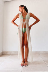 DEL MAR LONG TUNIC is the perfect addition to your beach wardrobe. With its silver lurex material and gold beading detail, it adds a touch of glam to any look. The front tie closure and left leg slit offer versatility and comfort. Hand wash cold for easy maintenance. One size fits XS-L. Paired with the Azusa/Cerritos Bikini Palmeira for a complete beach look.