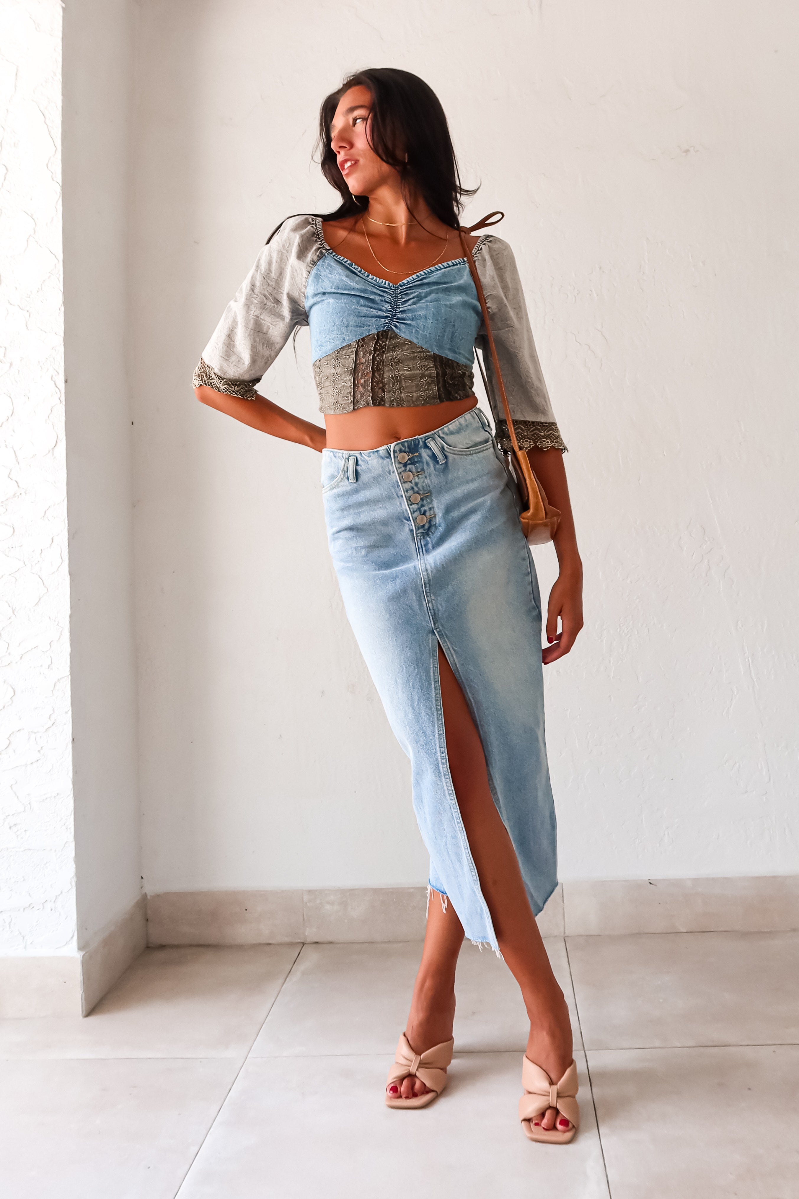 Queen Denim Crop Top! This mix denim crop top features a smock back for a comfortable fit and 3/4 sleeves with a unique crochet design. With elastic at the shoulders, you can easily switch up your look for an on or off shoulder style. The slight stretch and true to size fit make it a perfect staple for any occasion. And best of all, it pairs perfectly with our Melrose Denim Midi Skirt.