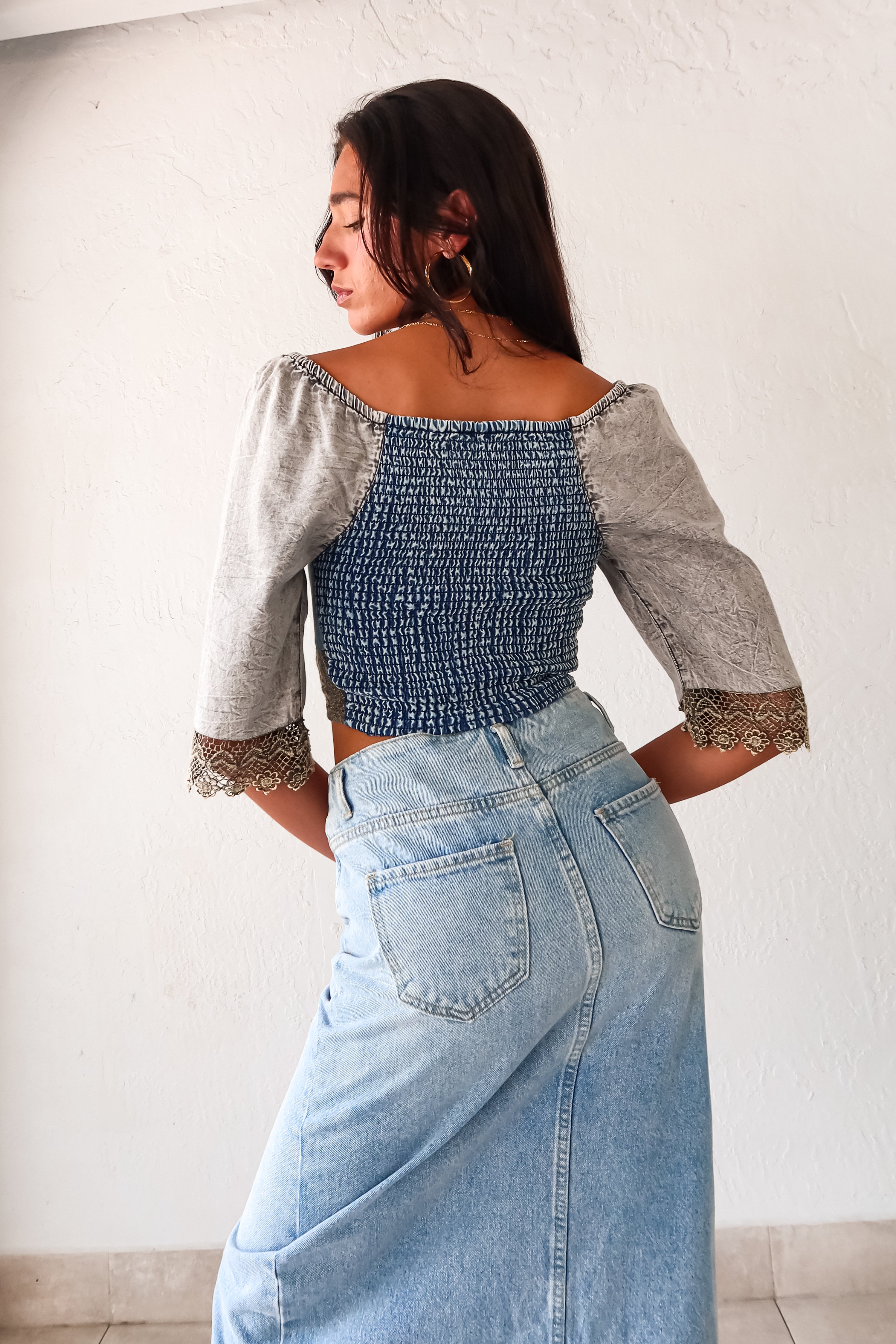 Queen Denim Crop Top! This mix denim crop top features a smock back for a comfortable fit and 3/4 sleeves with a unique crochet design. With elastic at the shoulders, you can easily switch up your look for an on or off shoulder style. The slight stretch and true to size fit make it a perfect staple for any occasion. And best of all, it pairs perfectly with our Melrose Denim Midi Skirt.