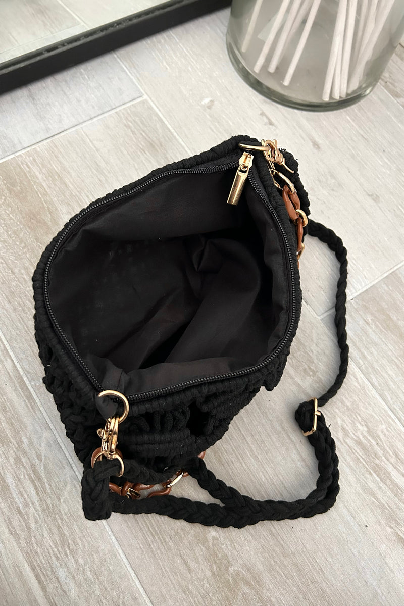 This black knit handbag adds a touch of boho-chic to any outfit. The acrylic gold hand strap and removable straps offer versatility, while the zipper closure keeps your belongings secure. Measuring 11 inches in length, 7 inches in height, and 1 inch in width, it's the perfect size for all your essentials.