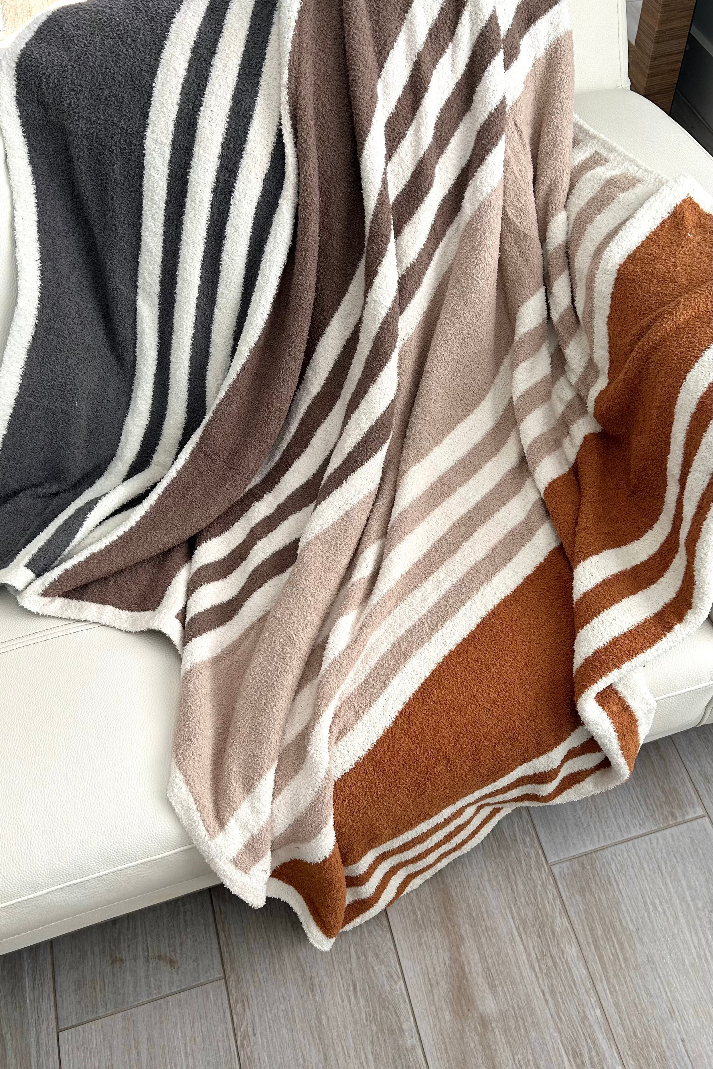 Stay cozy and stylish with our Striped Microfiber Blanket! Made of 100% polyester microfiber, this white blanket with navy, khaki, and brown stripes is perfect for snuggling up on chilly nights. Measures 50x60 inches. Upgrade your comfort game now!