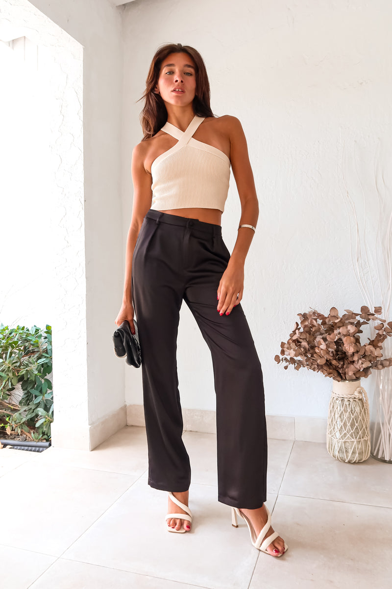 Get ready to make some bold moves with these black satin pants. The button and zipper closure, along with the elastic waist band, ensure a comfortable fit while the front pockets add functionality. Perfect for a night out on the town, these pants will have you looking stylish and feeling confident.