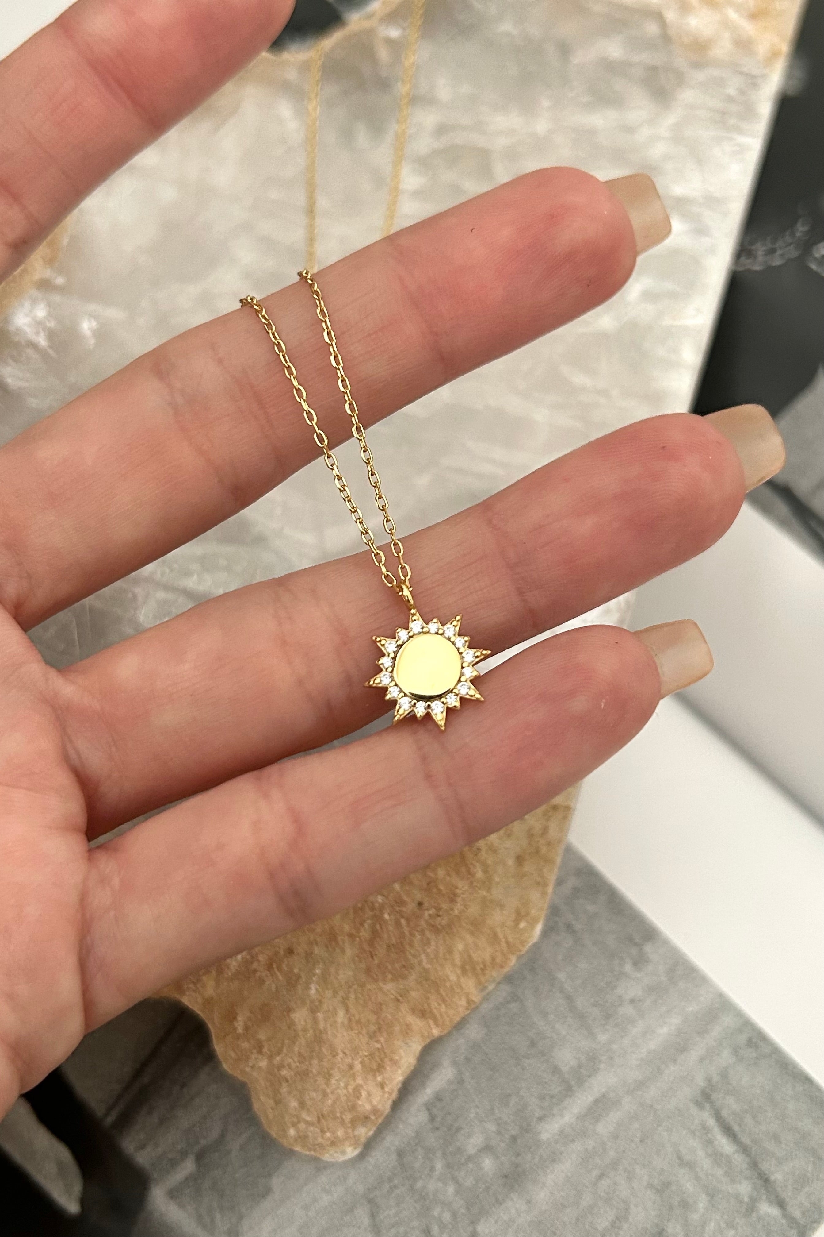 Add a golden ray of sunshine to your jewelry collection with our PAVE SUN RAY NECKLACE. Made with gold plated sterling silver, this necklace features a playful sun charm with gem details. Enjoy the benefits of tarnish resistance and hypoallergenic materials without sacrificing style!