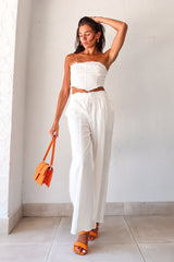 Get ready to turn heads with our FIRENZE COTTON PANT SET! Made from soft white cotton, this set features a bandeau top with a back tie closure, and pull string closure pants with an elastic waist band for a comfortable fit. With front pockets and unique leg hem and edge details, this set is both stylish and comfortable.