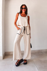 The COCO LINEN PANT SET is the perfect combination of comfort and style. This beige pant set features a playful open back with a beaded tie string, a convenient front chest pocket, and a bottom tie string with front pockets. The elastic waist band ensures a comfortable fit, while the rayon/linen fabric provides a lightweight and breezy feel. Complete the look with the Lonza Platform Sandal.