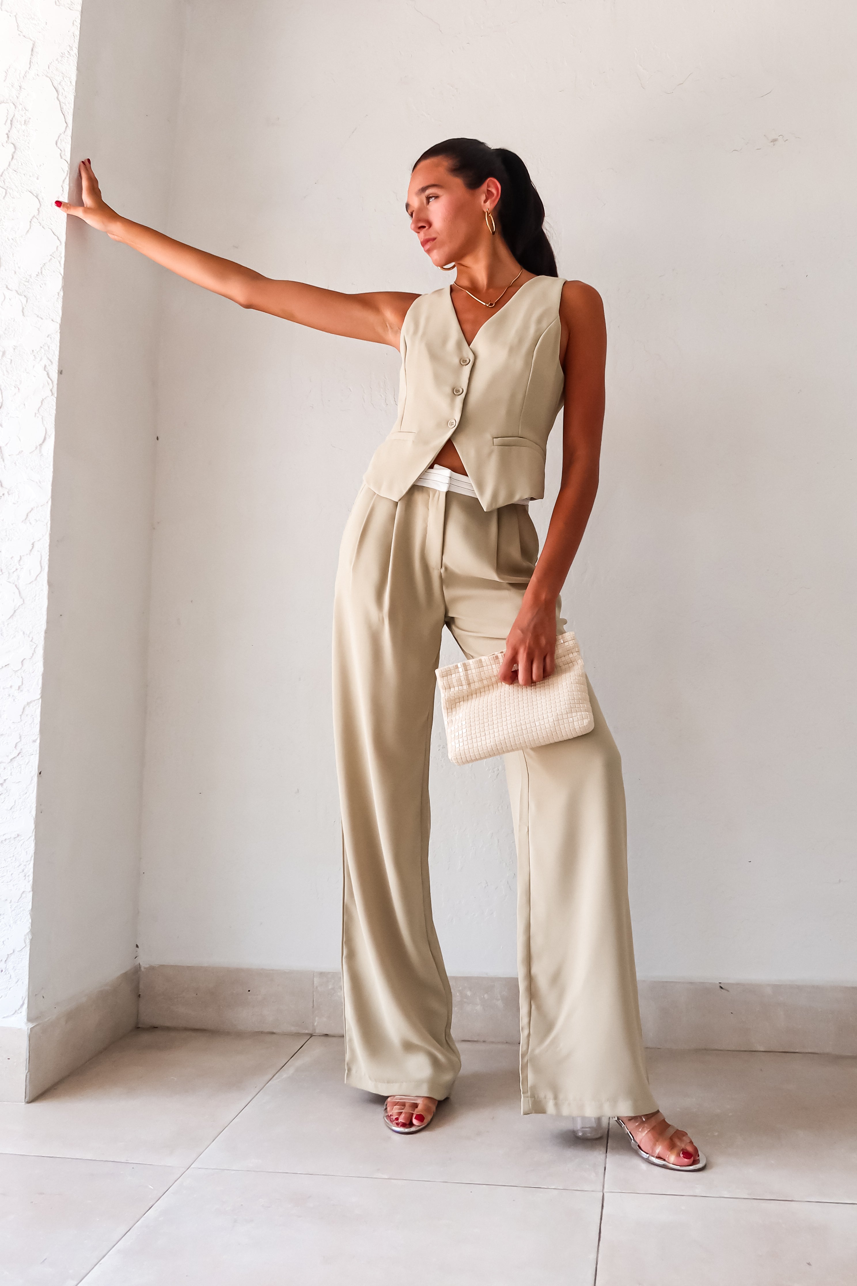 This sage green vest pant set adds a touch of charm to your wardrobe. Features a top with adjustable buckle silver detail and front button closure, while the pants offer a pleated design with white waist detail and front pockets. 