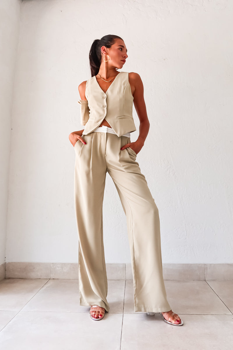 This sage green vest pant set adds a touch of charm to your wardrobe. Features a top with adjustable buckle silver detail and front button closure, while the pants offer a pleated design with white waist detail and front pockets. 