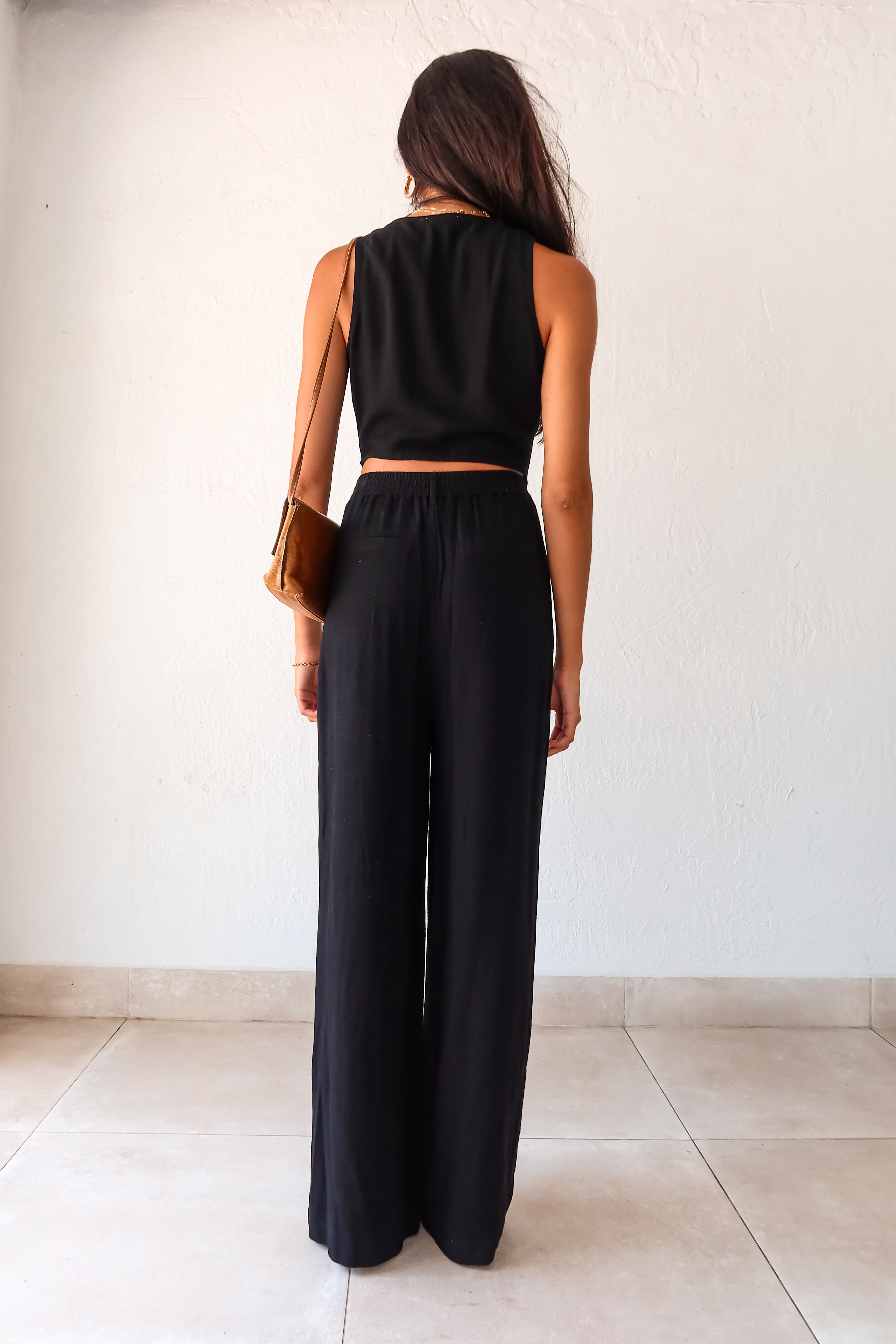 Slip into comfort and style with the ON THE WAY LINEN PANT SET in black. This versatile pant set features a vest top with a front button closure and pants with a zipper button closure. With front pockets, a stretchy waist back, and a lined top, it's the perfect mix of fashion and functionality. No need to compromise comfort for style, as this non-stretch set runs true to size.