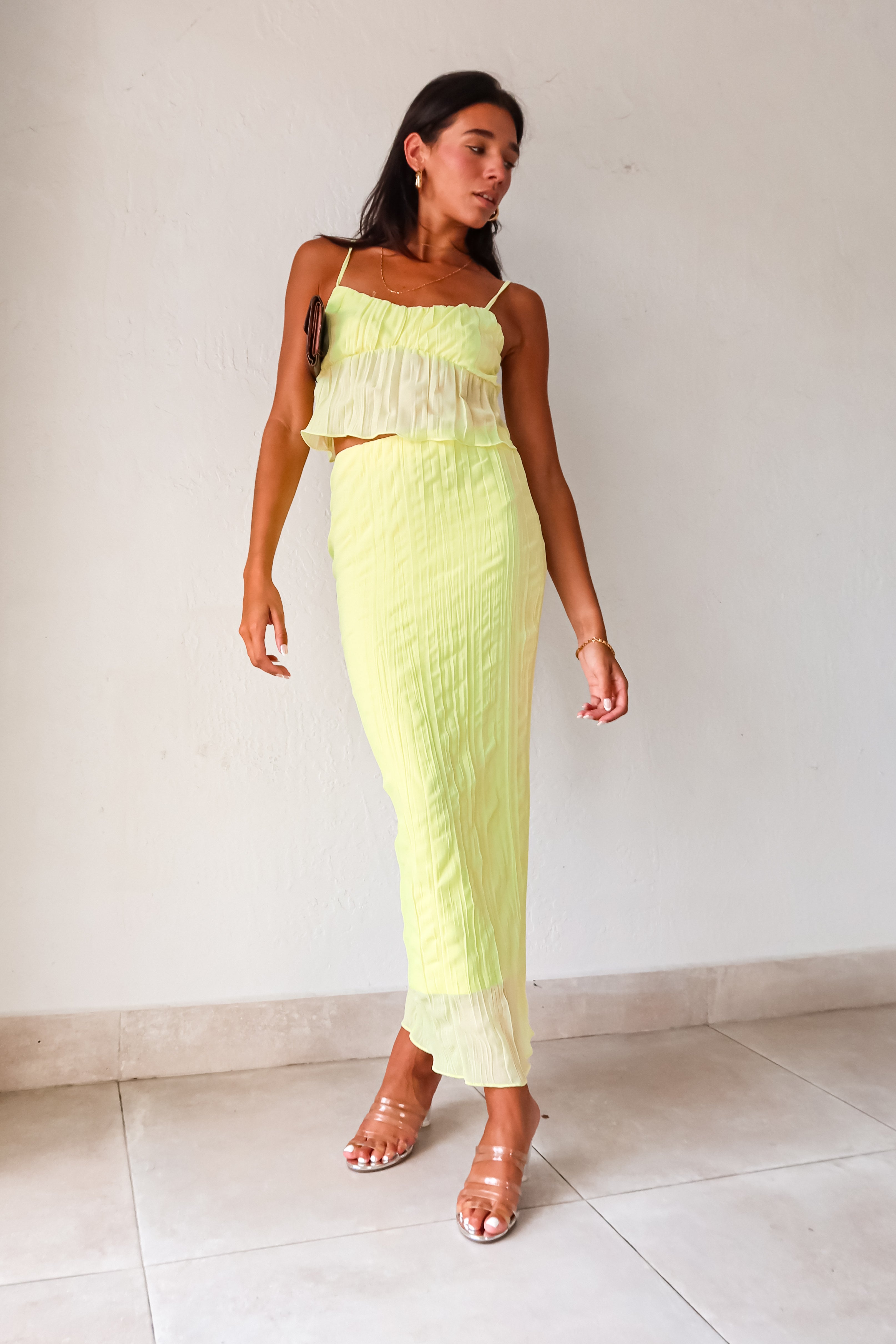 The LUELLA PLISSE CHIFFON SKIRT SET in fluorescent yellow/green is sure to make a statement. The crop top features adjustable shoulder straps and is lined at the bust for added comfort. The midi skirt has an elastic waistband and is also lined. Perfect for a fun and playful look. Hand wash cold.