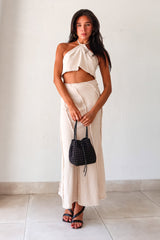  TOP TIER SKIRT SET! This beige light denim maxi skirt set features a halter cropped top that ties around the neck and a high waist maxi skirt with a raw edge design and hem. With a flattering fit and non-stretch, non-lined fabric, this set is perfect for any occasion. Pair it with our Becca Woven Mini bag for a complete look. 