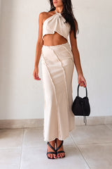  TOP TIER SKIRT SET! This beige light denim maxi skirt set features a halter cropped top that ties around the neck and a high waist maxi skirt with a raw edge design and hem. With a flattering fit and non-stretch, non-lined fabric, this set is perfect for any occasion. Pair it with our Becca Woven Mini bag for a complete look. 