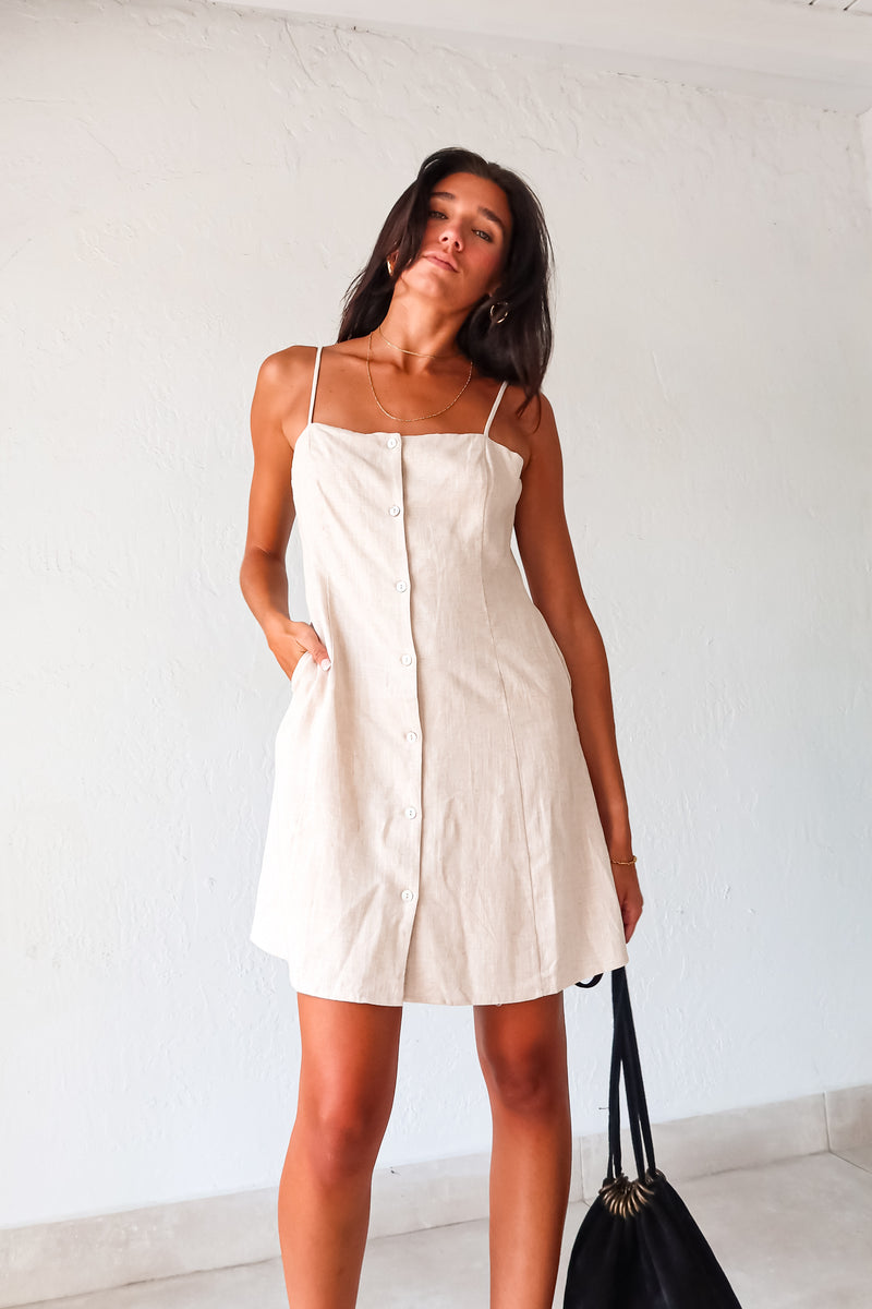 Stay cool and chic in our Ventura Linen Mini Dress. Made from light khaki linen, this loose fitting shift dress is perfect for fashion forward gals. Featuring adjustable shoulder straps, a front button closure, and side pockets, this dress is both stylish and functional. Lined and non-stretch, it runs true to size and can be easily cared for with a simple hand wash. 