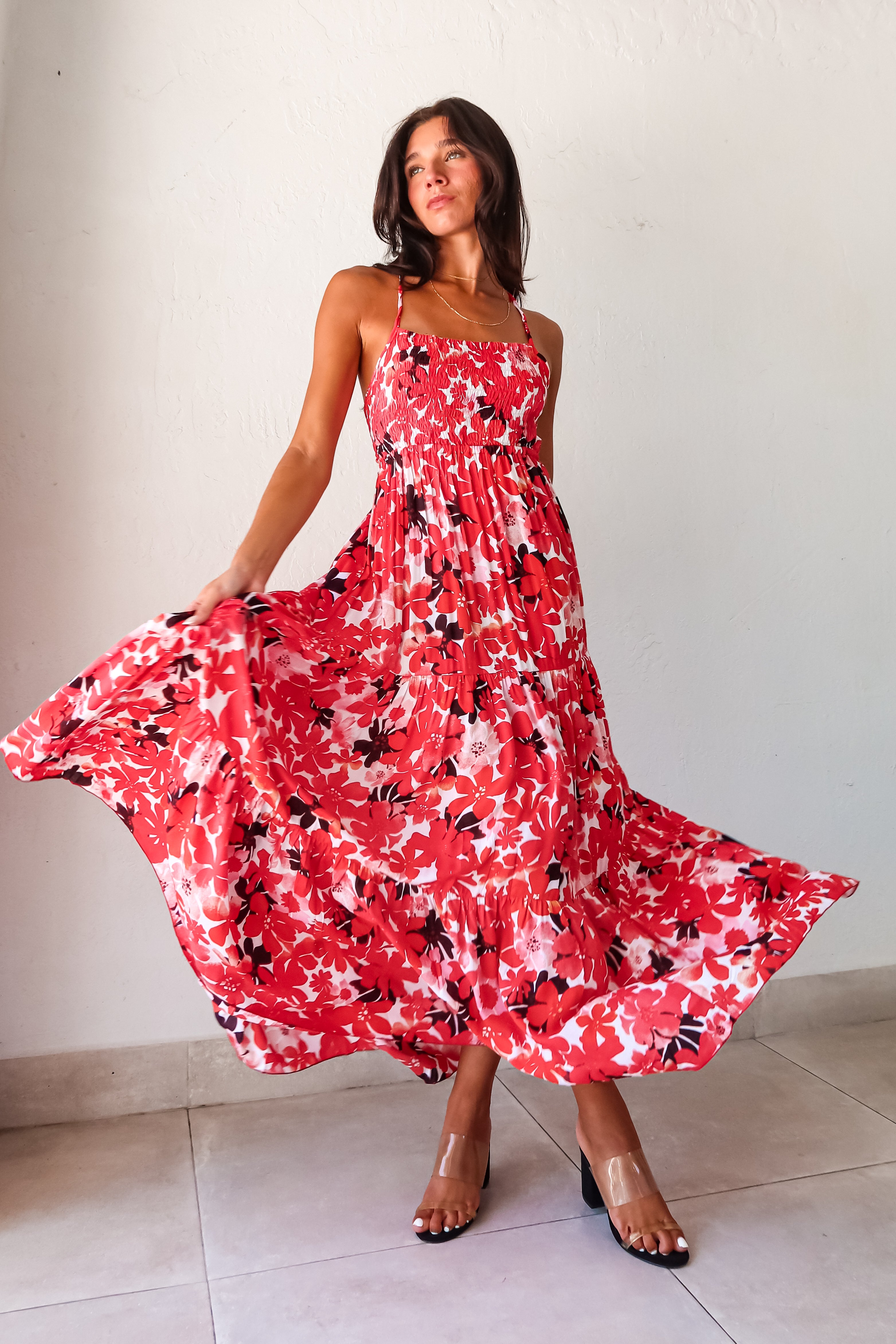 Be the life of the party in our WONDERLAND VISION MAXI DRESS! This floral dress features a playful red, pink, white, and black design, with an adjustable tie string back and smocked bust for a comfortable and flattering fit. With non-lined, non-stretch material and one size fitting XS-L, you'll be sure to turn heads in this quirky, fun dress.