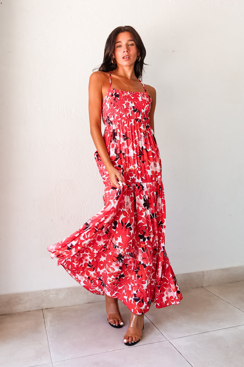 Be the life of the party in our WONDERLAND VISION MAXI DRESS! This floral dress features a playful red, pink, white, and black design, with an adjustable tie string back and smocked bust for a comfortable and flattering fit. With non-lined, non-stretch material and one size fitting XS-L, you'll be sure to turn heads in this quirky, fun dress.