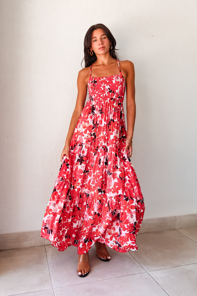 Be the life of the party in our WONDERLAND VISION MAXI DRESS! This floral dress features a playful red, pink, white, and black design, with an adjustable tie string back and smocked bust for a comfortable and flattering fit. With non-lined, non-stretch material and one size fitting XS-L, you'll be sure to turn heads in this quirky, fun dress.