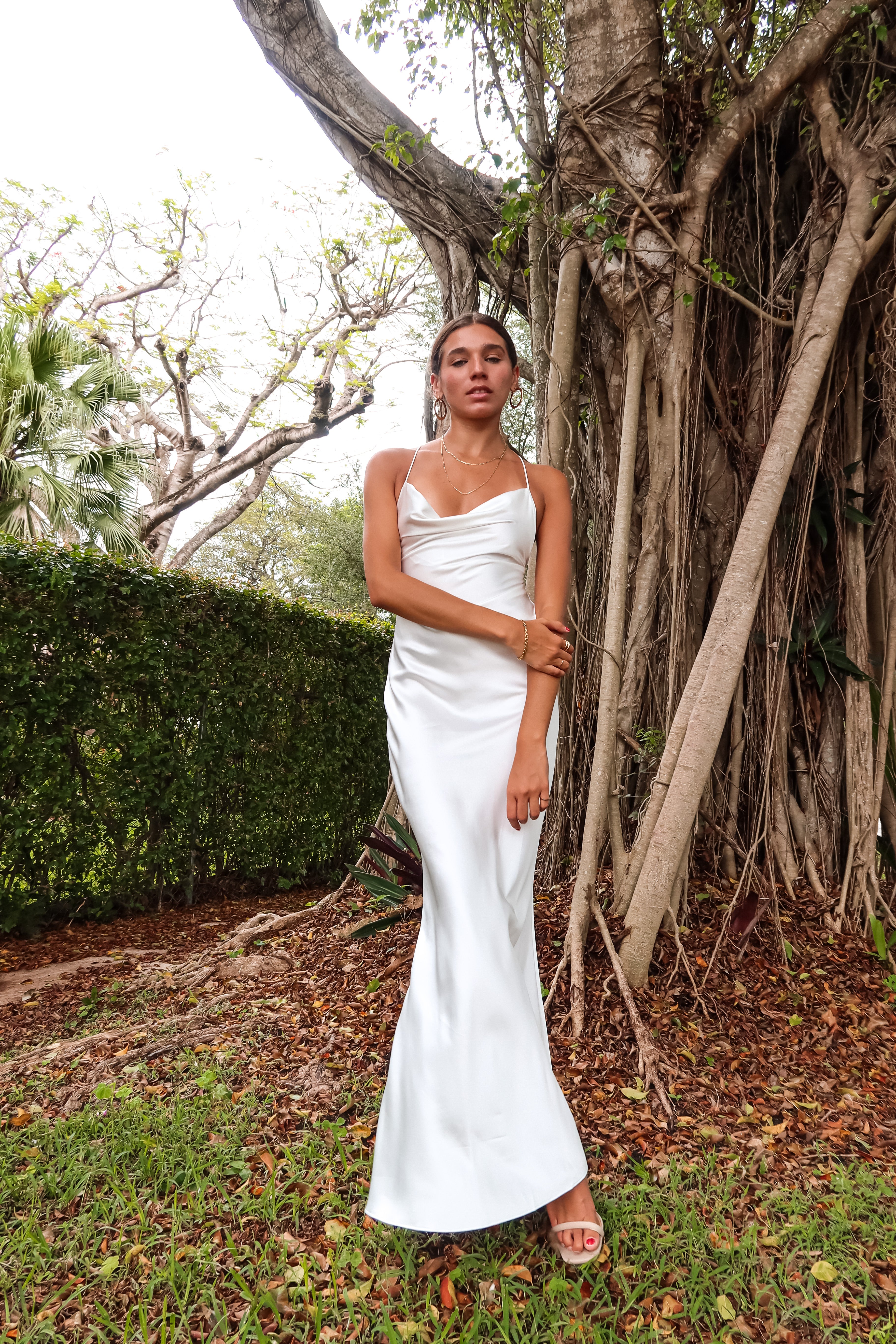 Get ready to party in our white satin maxi dress! Luxurious and thick satin fabric provides ultimate comfort and style. Adjustable string tie with gold chain detail adds a touch of glamour. Cowl neck bust and low back create a stunning silhouette. Let's get this party started!