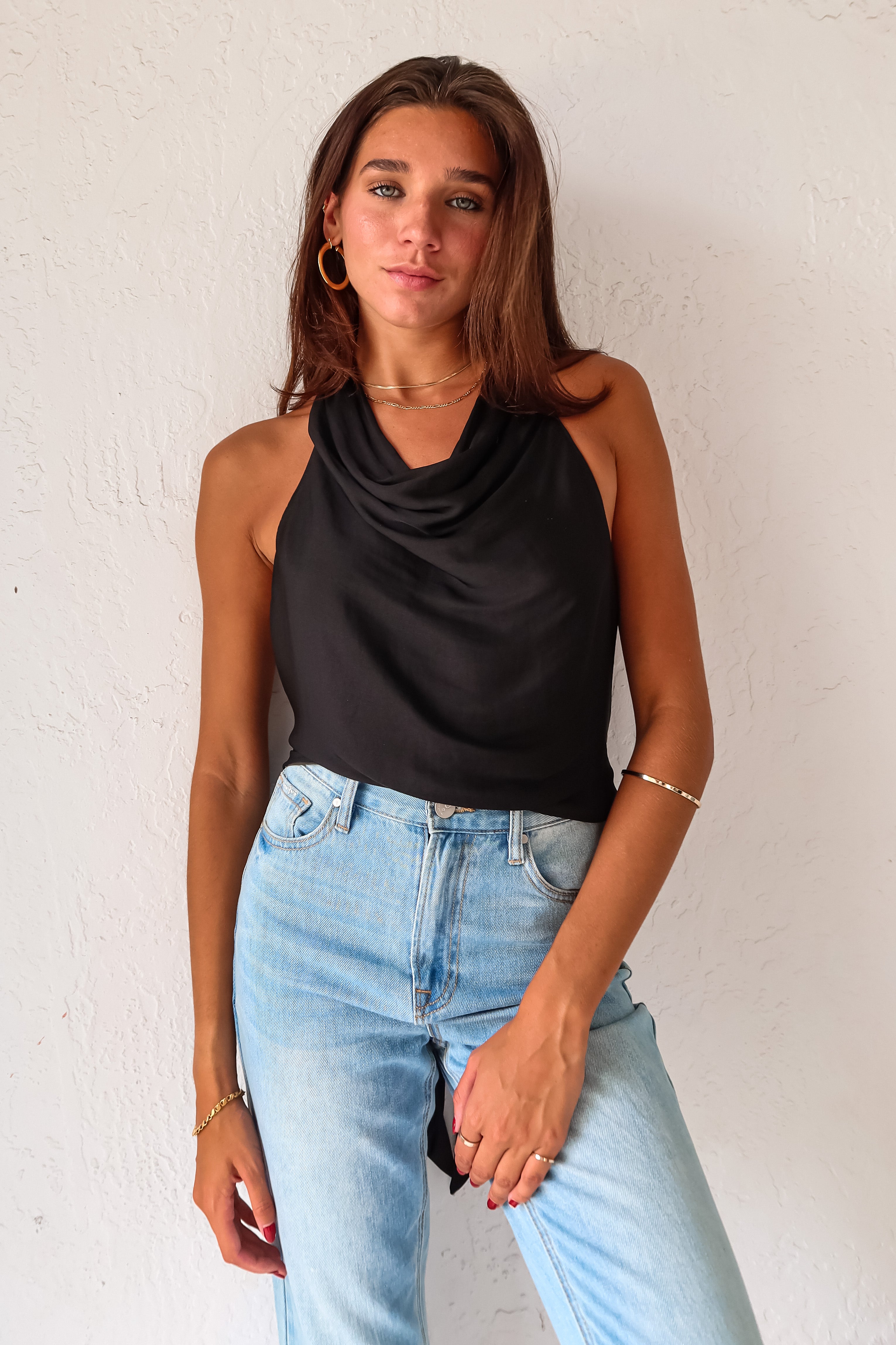 TGIF Satin Wrap Top in sleek black. The back tie around the neck and waist allows for a customizable fit, while the cowl neck adds a touch of elegance.